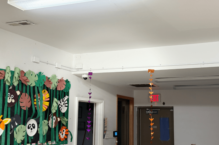 Decorated hallway with hanging Halloween crafts and colorful panda mural on the left wall