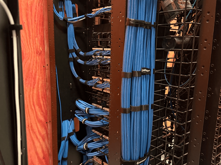 Vertical blue and black network cables neatly organized in a server rack