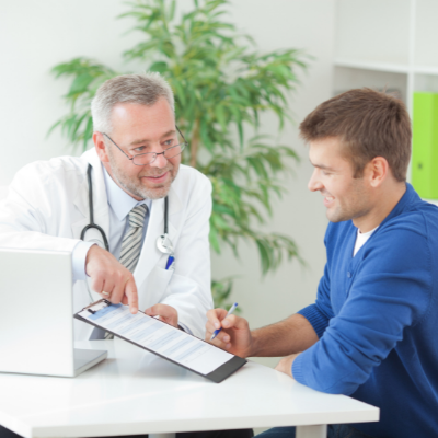 Doctor showing a clipboard to a patient in a bright clinic office