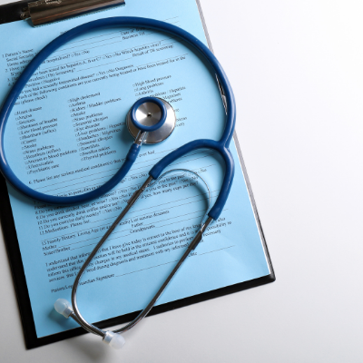 Blue stethoscope over a medical document with a magnifying glass, suggesting review or inspection