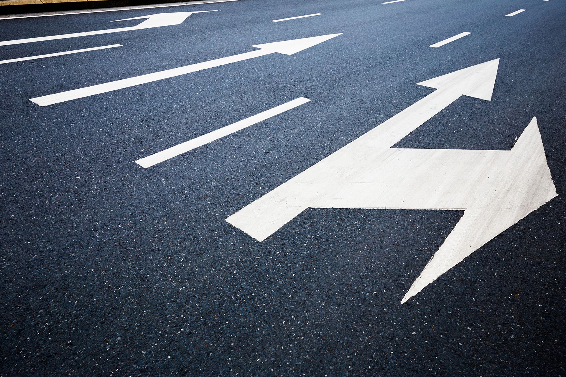 A road with arrows painted on it pointing in opposite directions