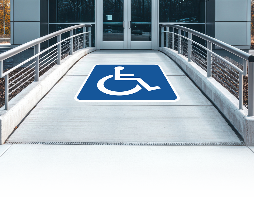 A ramp with a handicap sign on it is leading to a building.