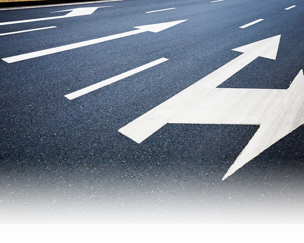 A road with white arrows pointing in opposite directions