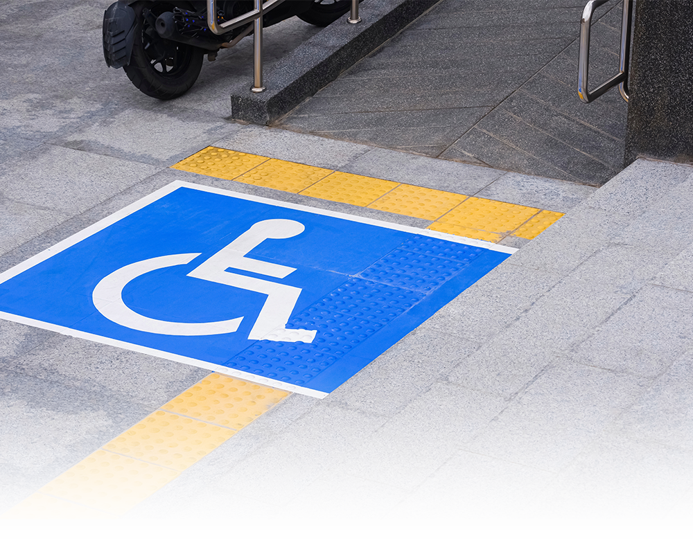 A blue and white handicap sign is painted on the sidewalk