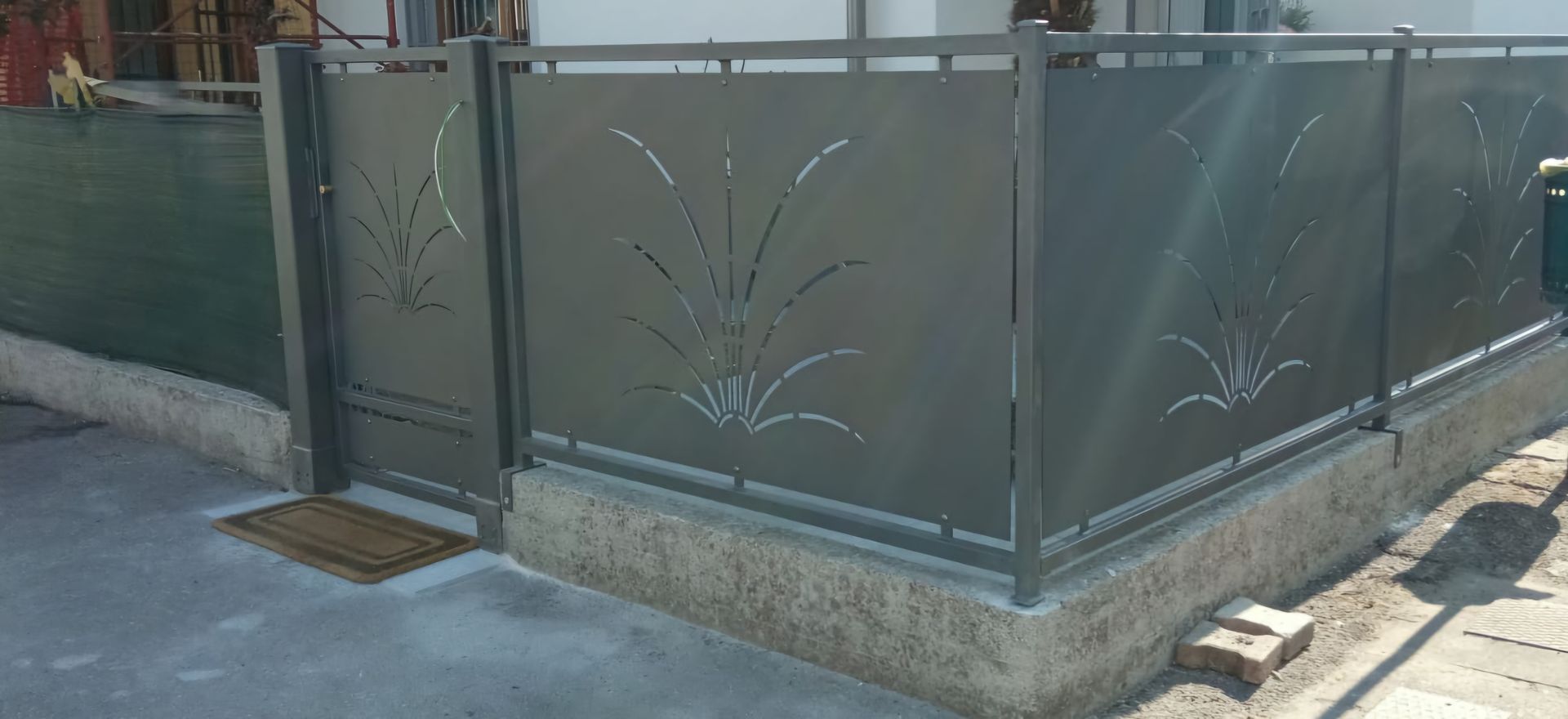 Una recinzione metallica con un cancello nell'angolo di una casa