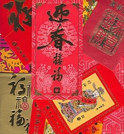 Red envelopes with Chinese characters and symbols, for a holiday celebration.