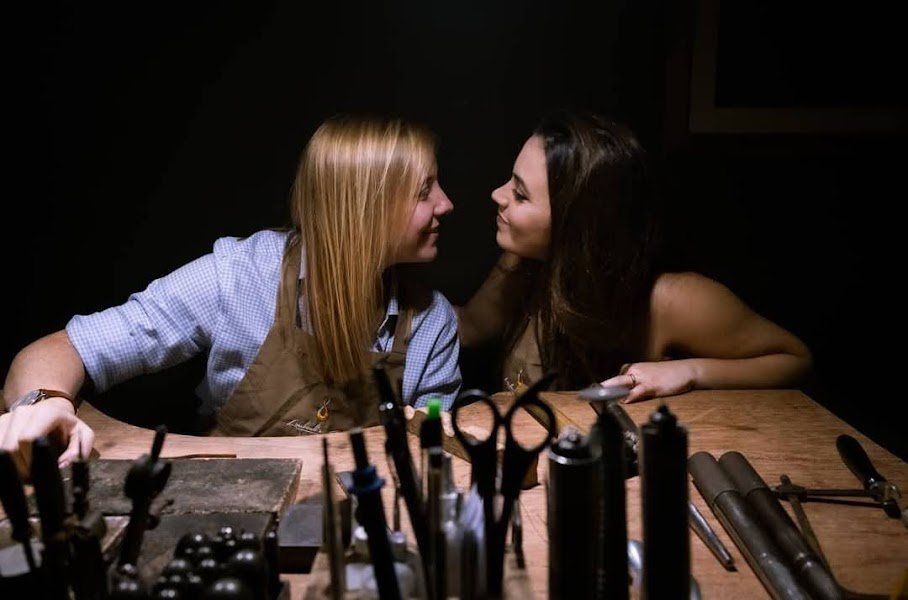 Duas mulheres estão sentadas à mesa olhando uma para a outra.