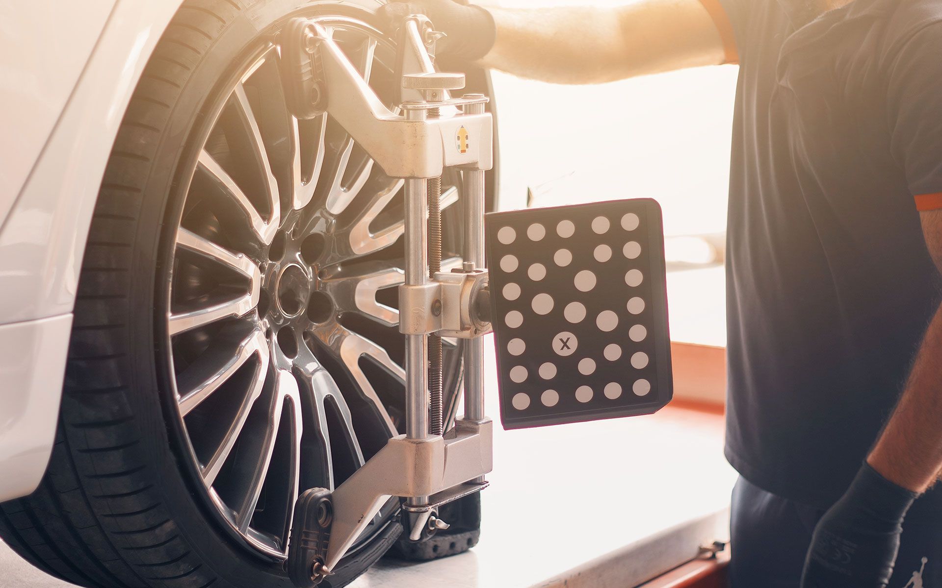 A man is adjusting a car wheel with a machine.