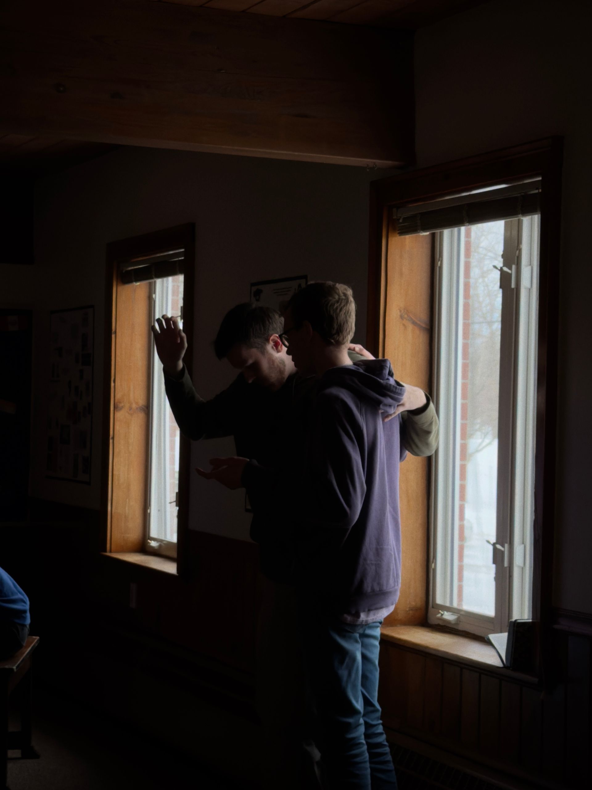 a student praying for another student during a chapel service