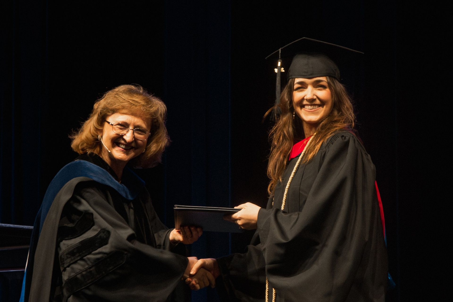 A female student receives her degree during commencement