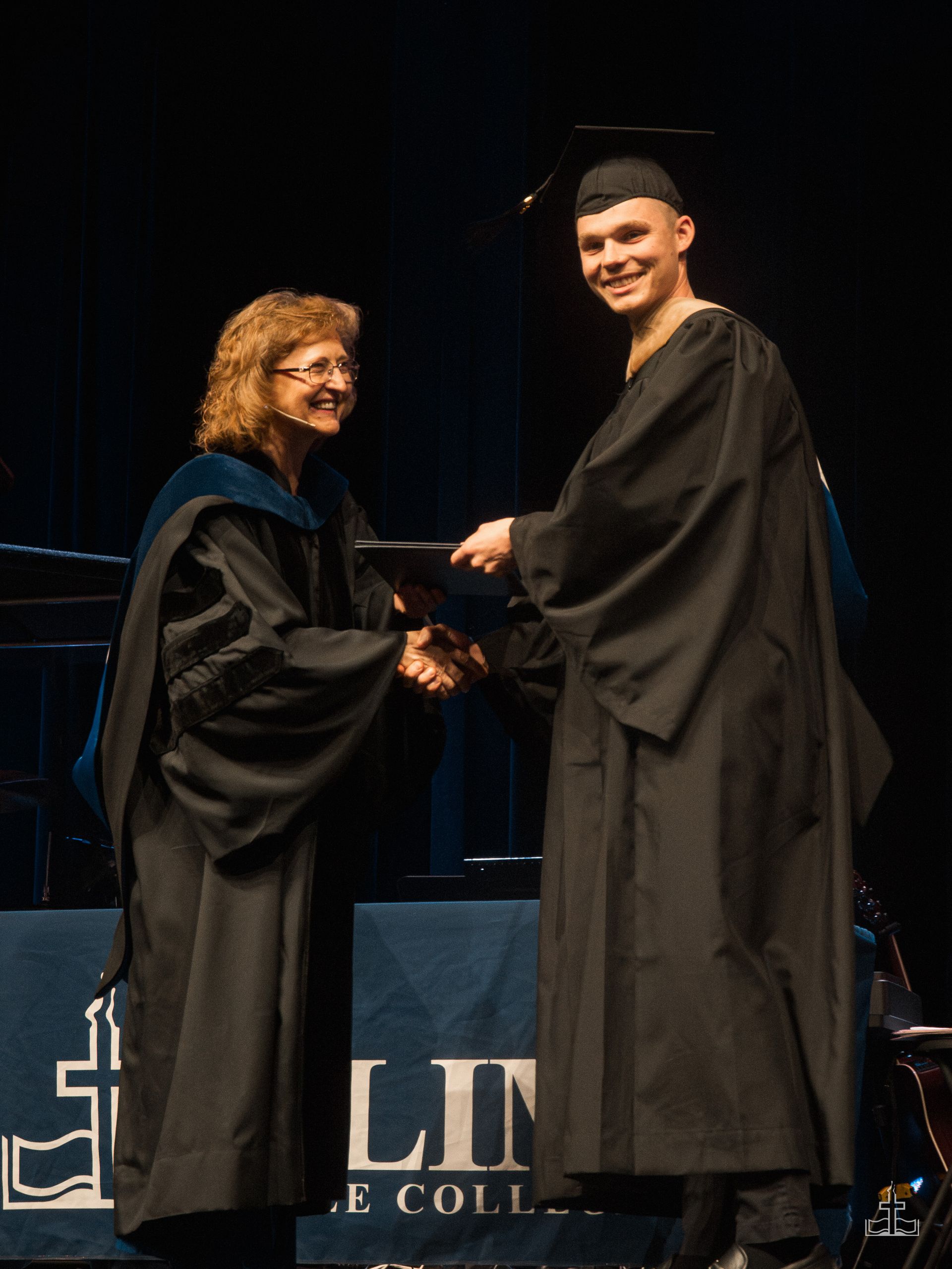 A student receives a diploma on stage at graduation