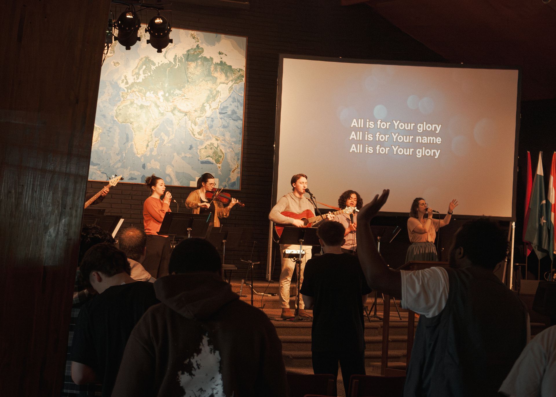 a girl playing piano and singing during chapel