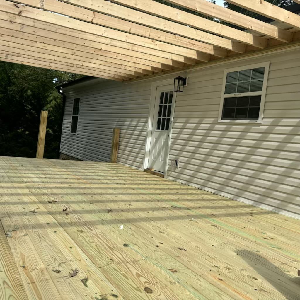 A wooden deck is under construction in front of a house.
