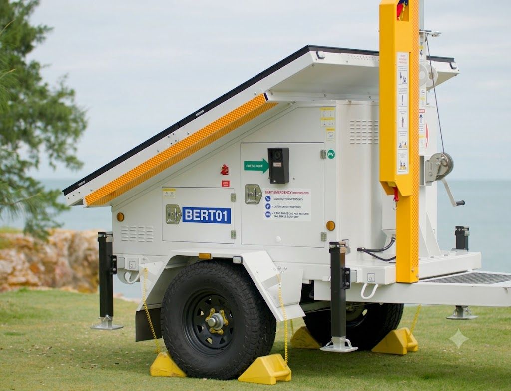 White portable power trailer with solar panel roof and yellow support posts on grass