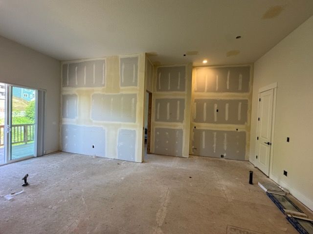 Interior view of a room under construction; drywall partially installed on walls.