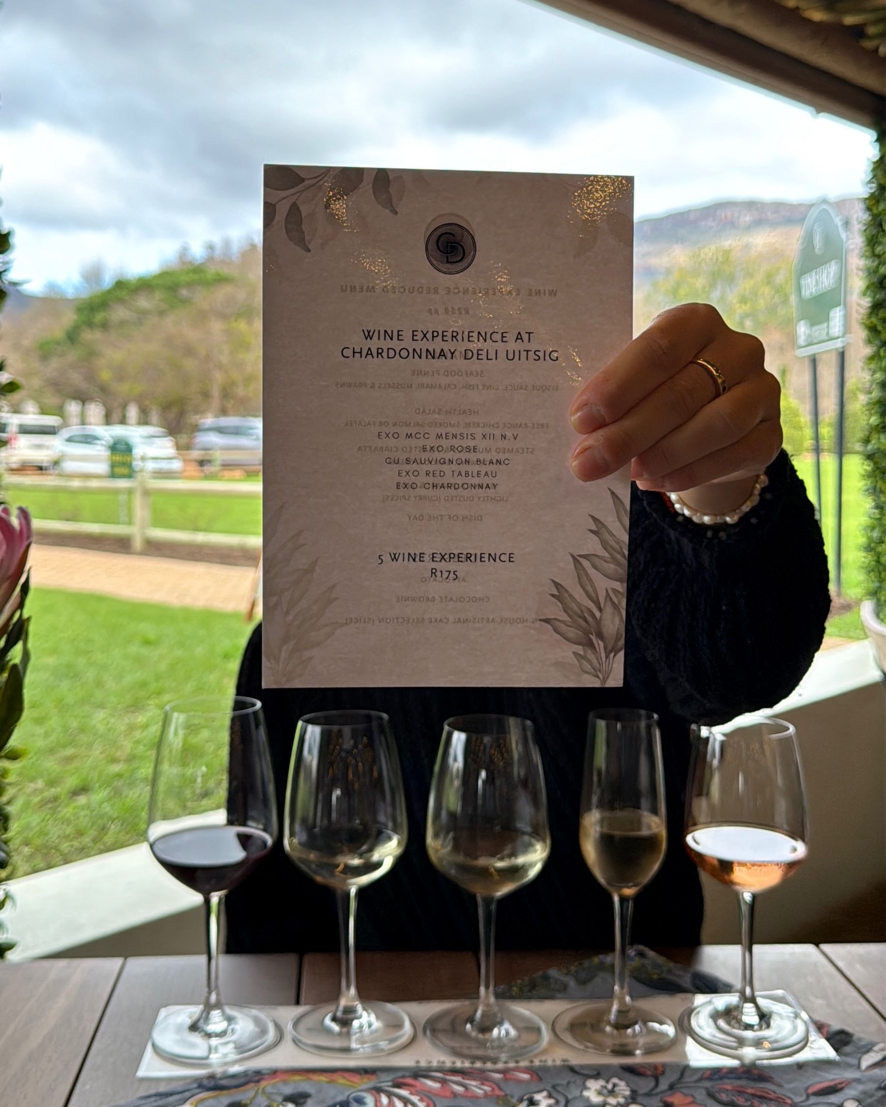 Paige is holding the Chardonnay Deli Uitsig wine experience menu
