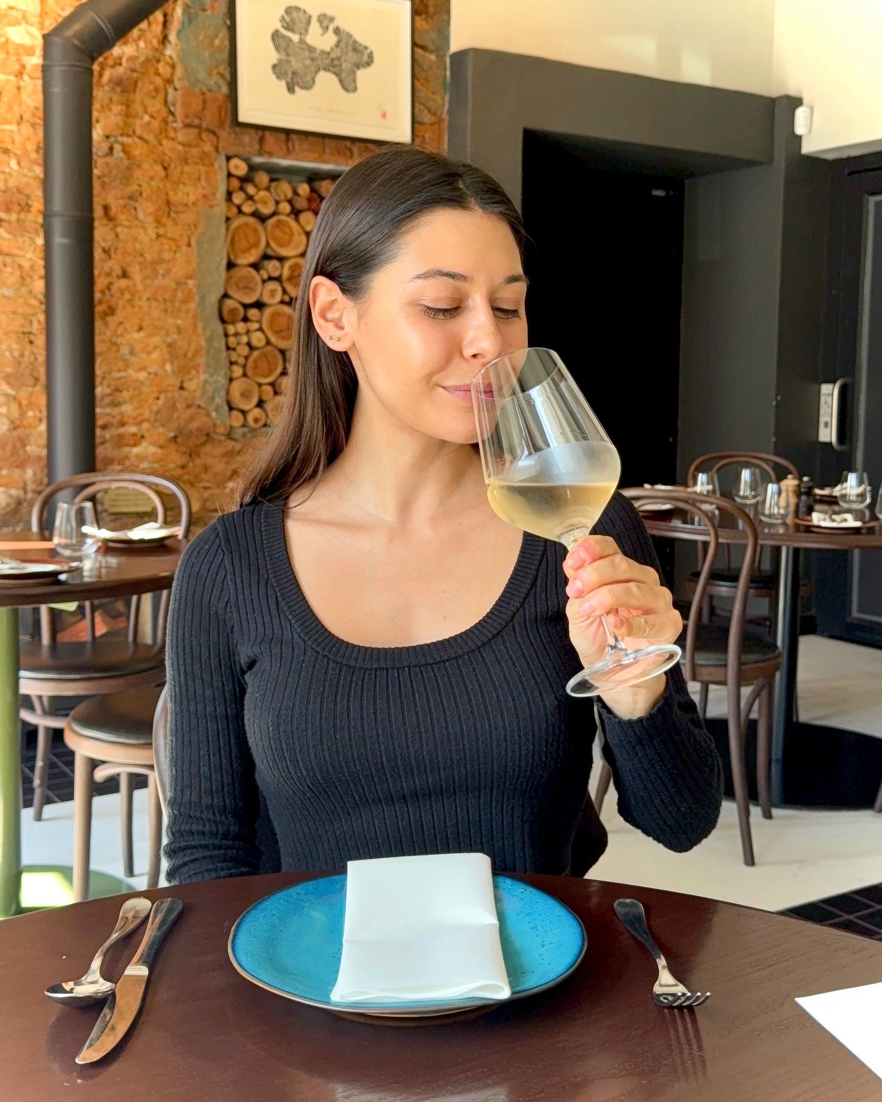 Paige swirling and smelling white wine during lunch at Chefs Warehouse & Canteen Cape Town