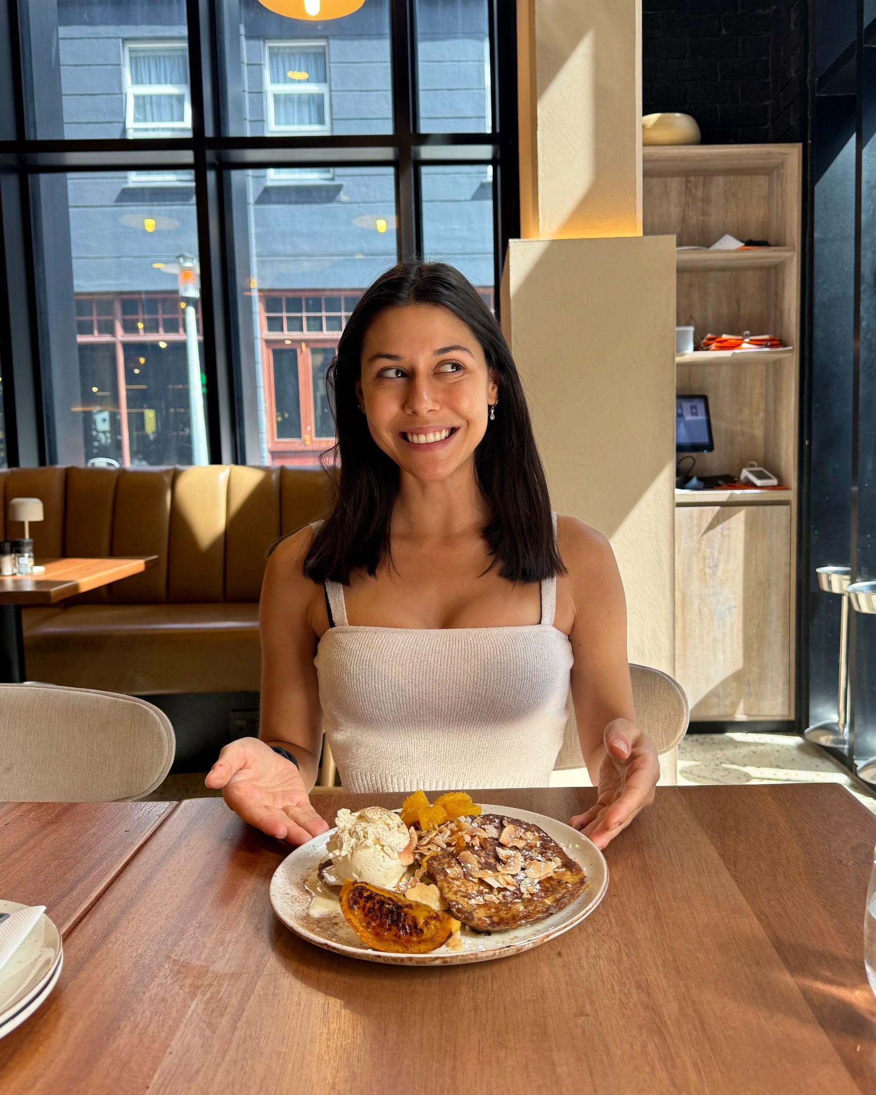 Paige smiling while holding Florentin toast at Bree Street restaurant