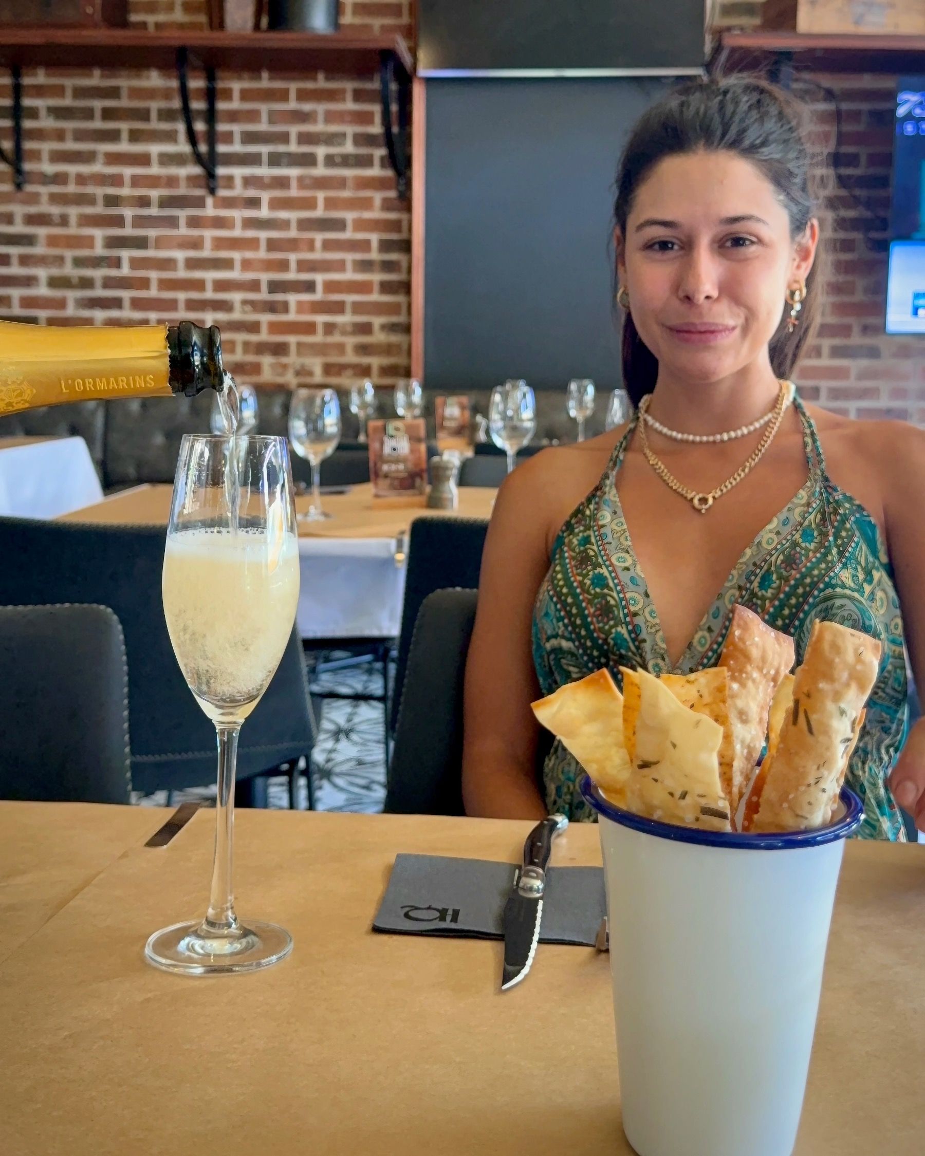 Paige smiling as bubbles are poured at HQ Steakhouse in Century City, polished steakhouse atmosphere and warm lighting