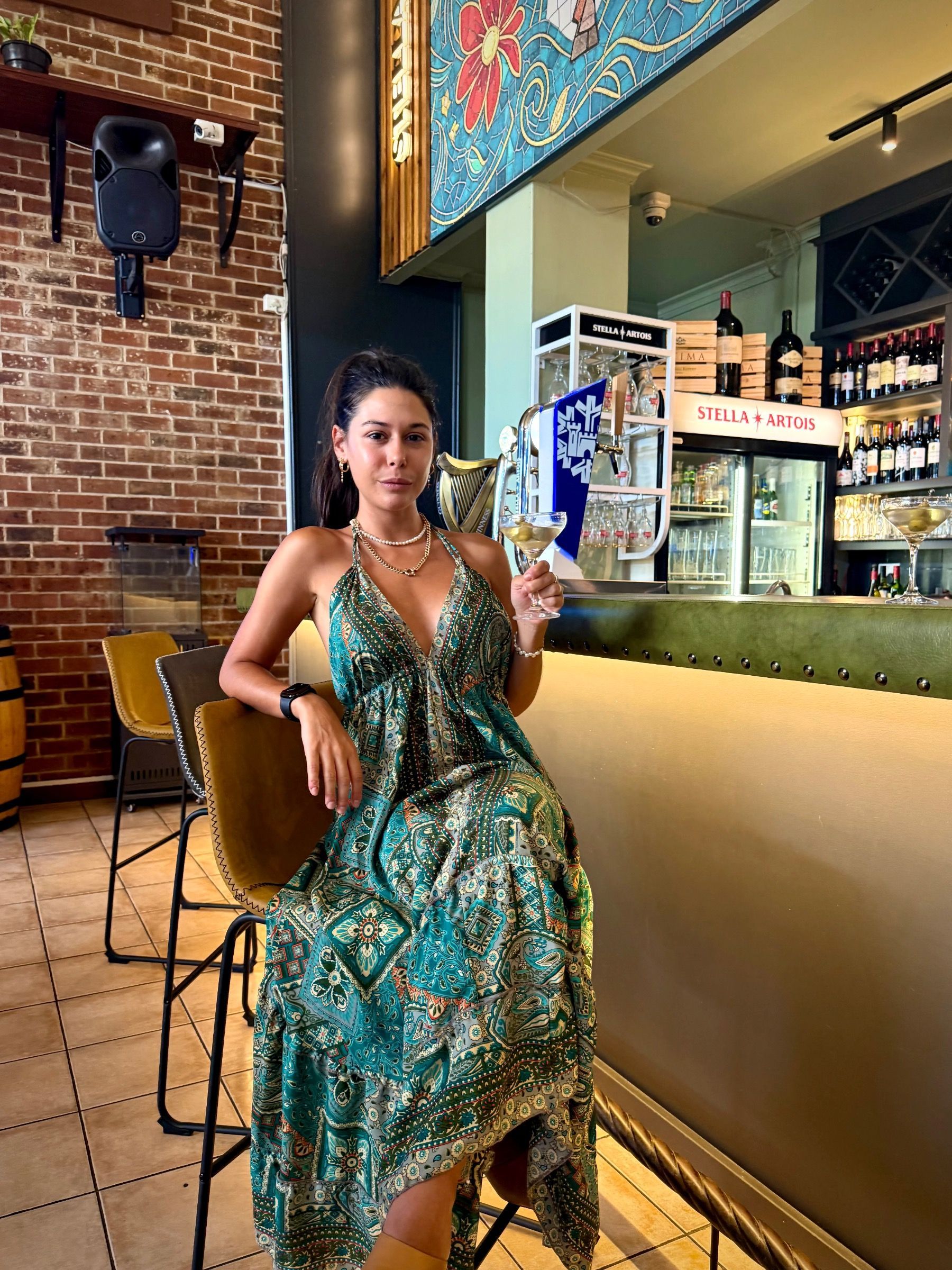 Paige holding a cocktail at HQ Steakhouse Century City, relaxed steakhouse bar setting with modern interior detail