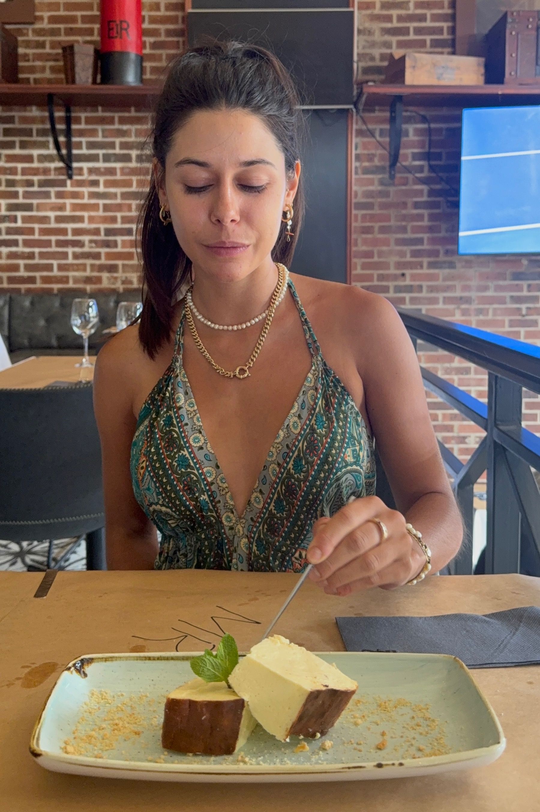 Paige eating burnt Basque cheesecake served at HQ Steakhouse Century City, creamy centre with caramelised top 