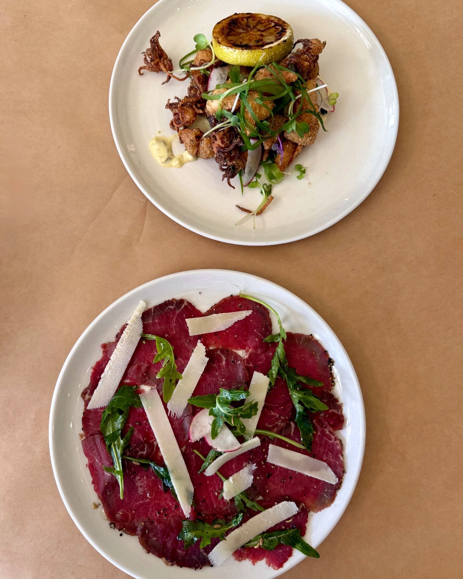 Paige enjoying salt and pepper calamari with lemon aioli and beef fillet carpaccio with parmesan and fennel at HQ Steakhouse