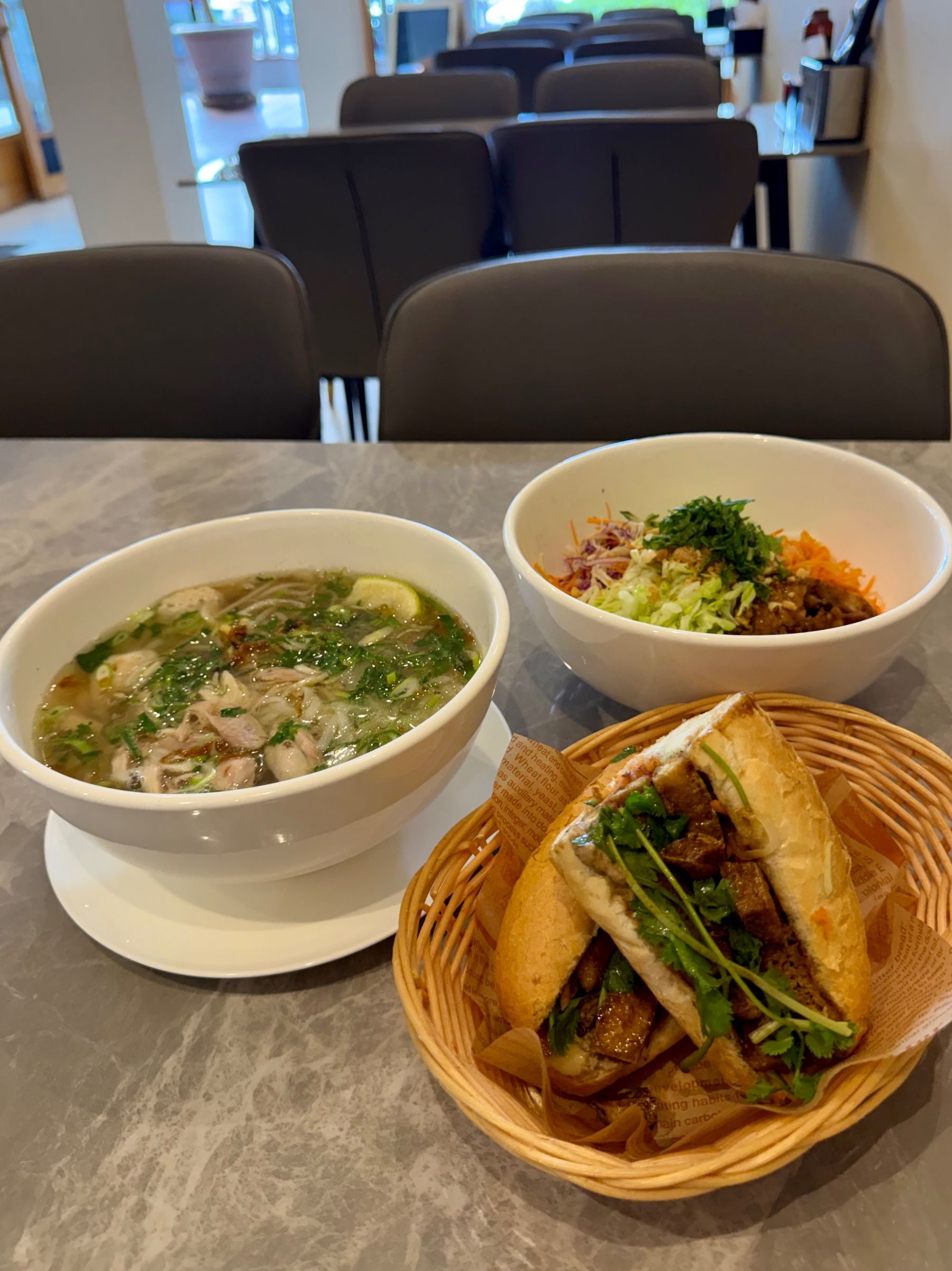 Pho, vermicelli bowl and banh mi on table