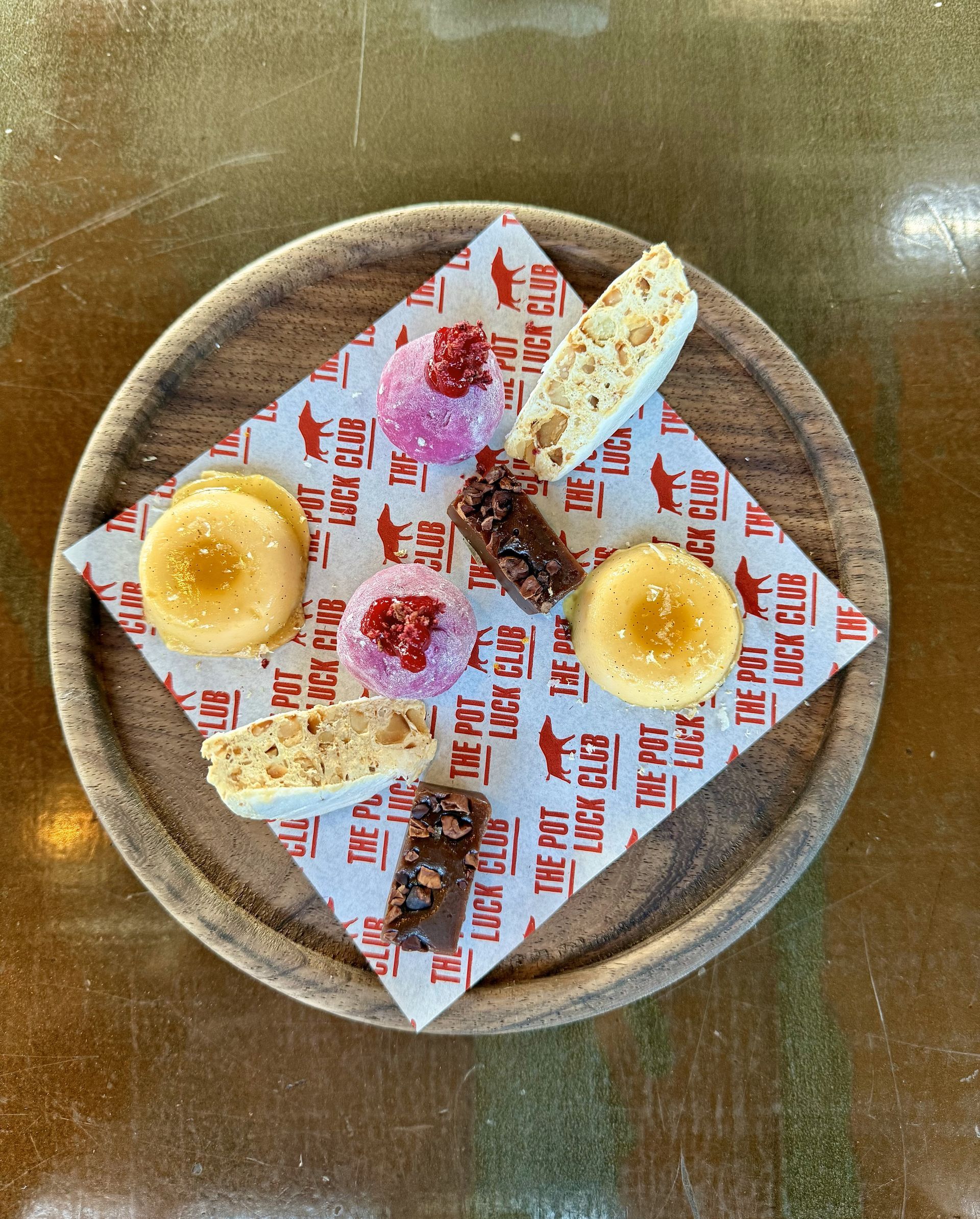 Dessert plate with cookies and bars on a wooden tray. Red and white patterned paper liner.