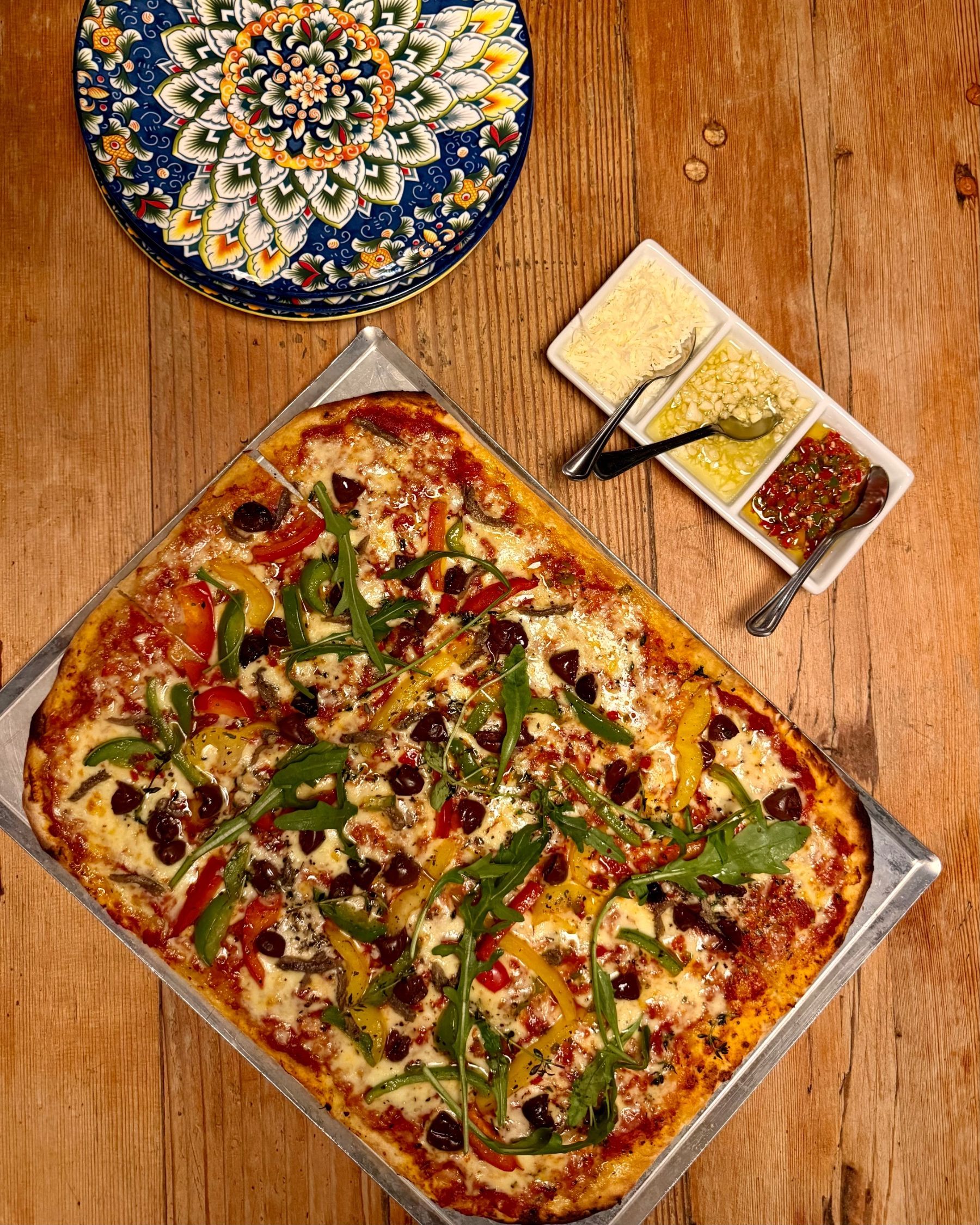 Thin-crust sheet pan pizza topped with fresh ingredients at Jerry’s