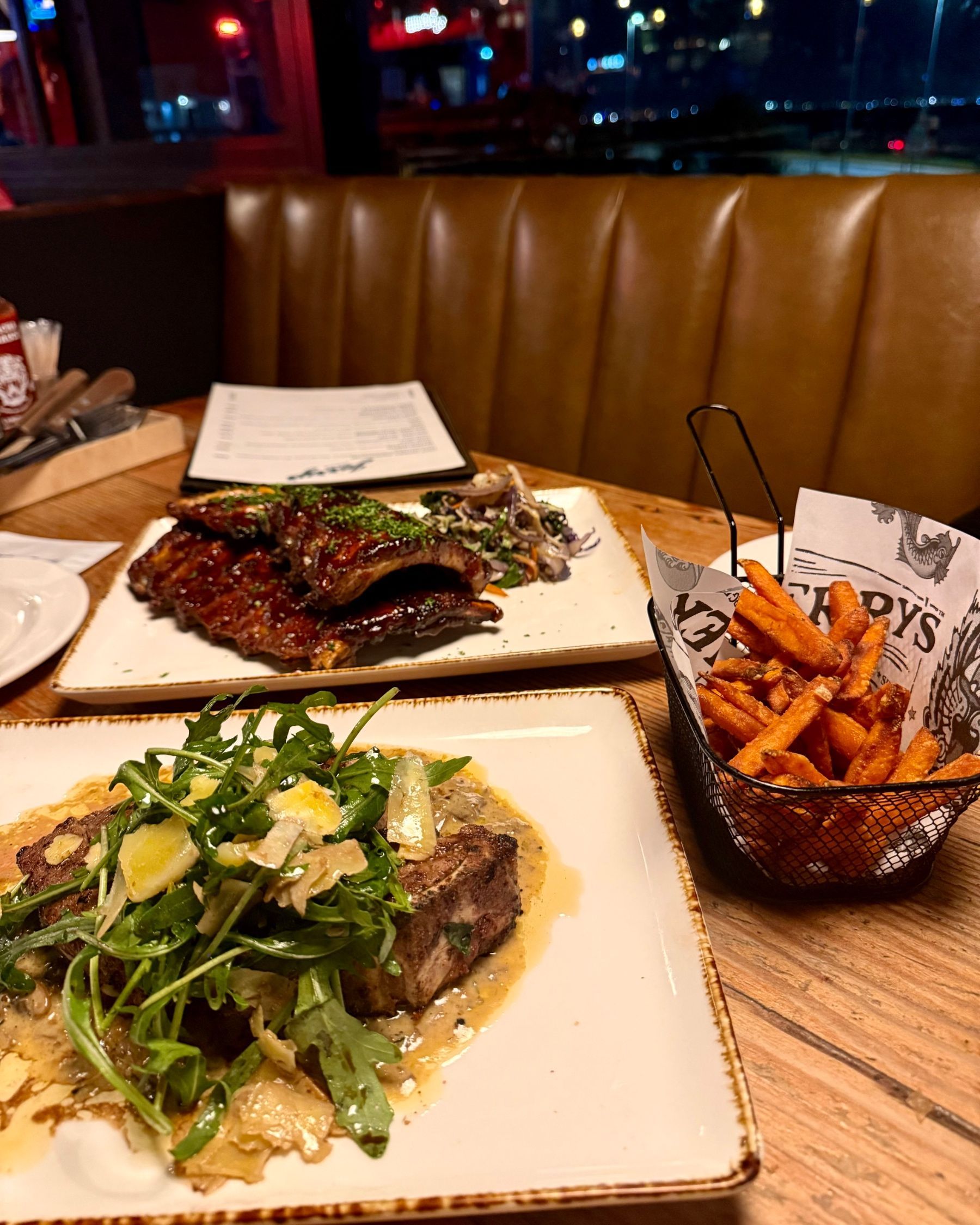 Steak, ribs and sweet potato fries on the table at Jerry’s
