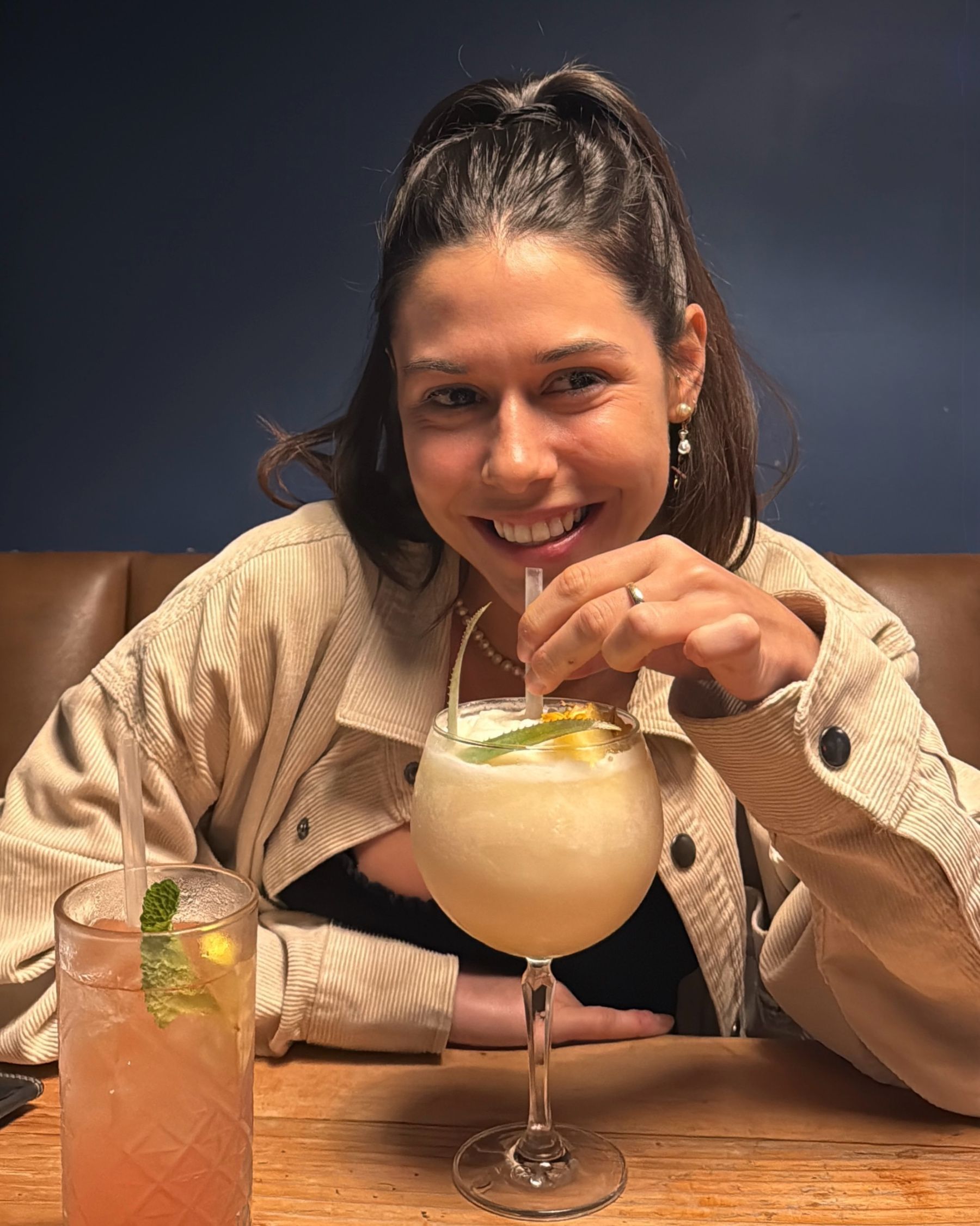 Paige drinking a piña colada cocktail at Jerry’s
