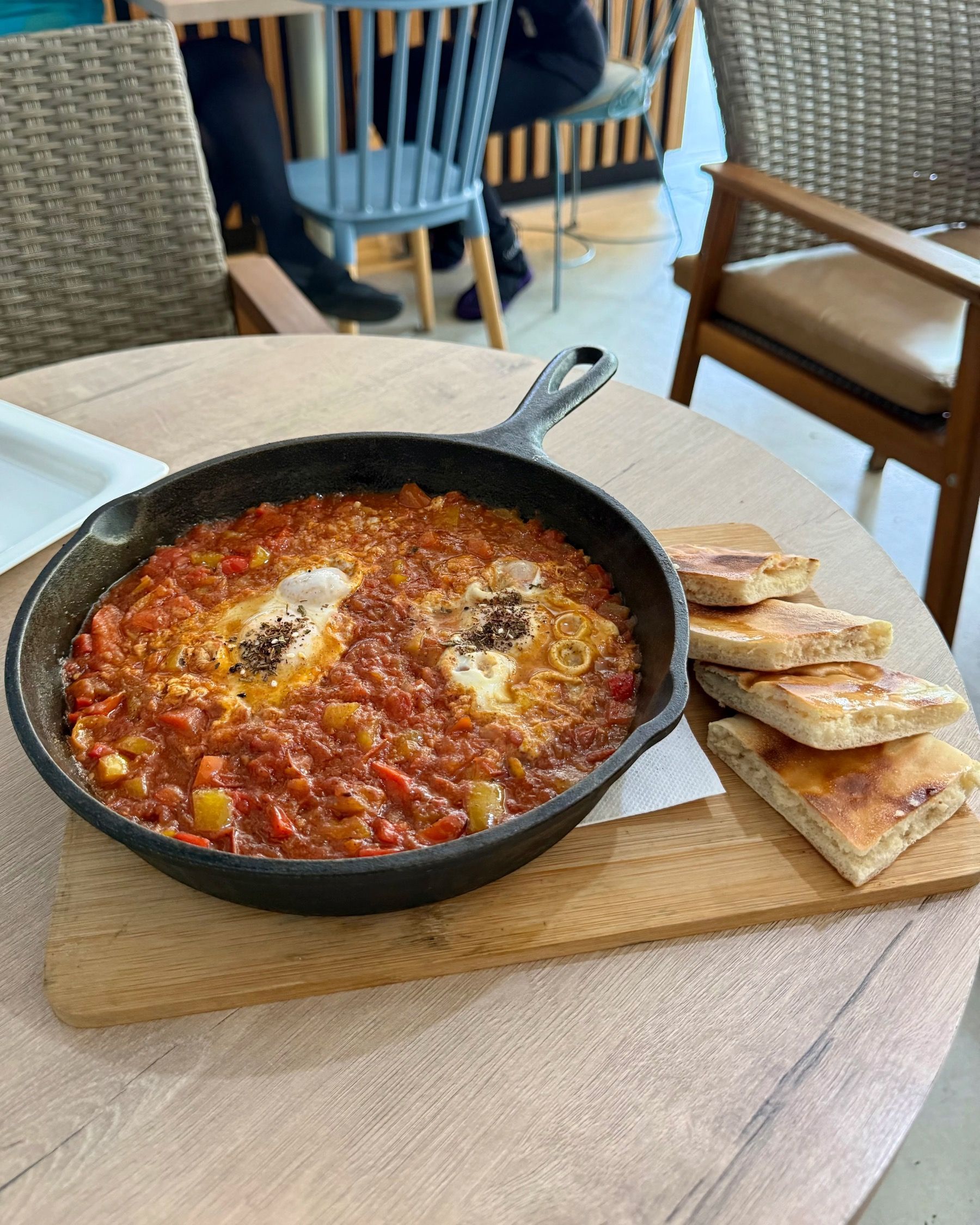 Shakshuka with baked eggs in spiced tomato sauce and warm pita bread at Lazari Café in Gardens, Cape Town