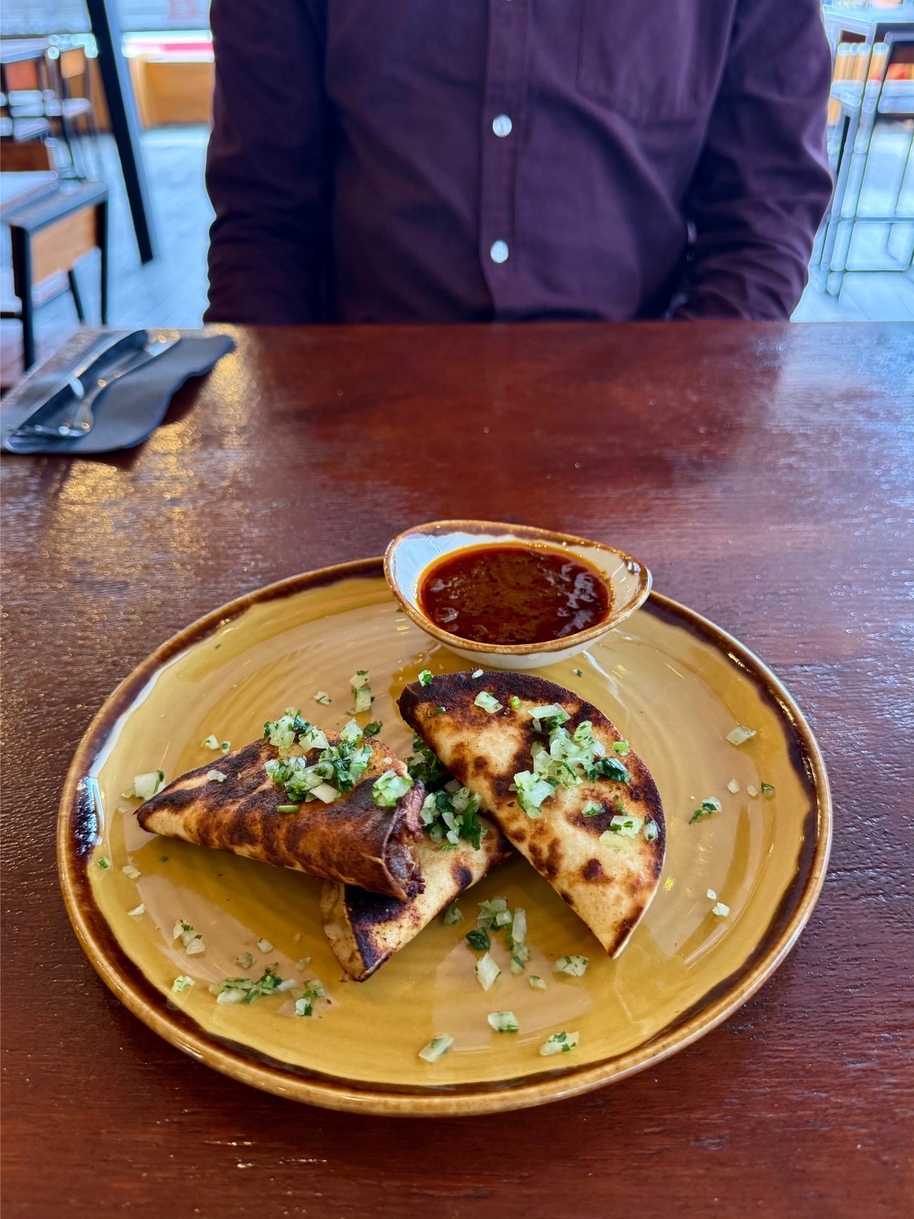 Lamb quesabirria taco with dipping jus at Mexicola Locale
