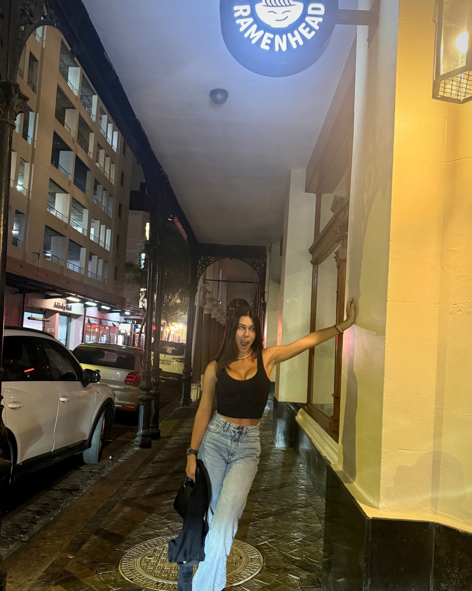 Paige is posing outside Ramenhead Cape Town at night