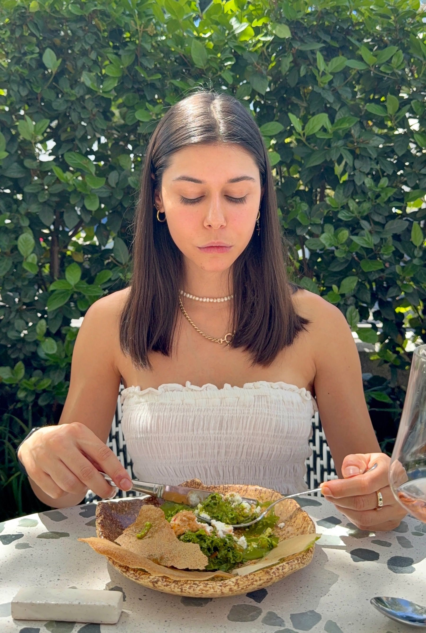 Paige eating charred green tartare with paneer and palak sauce at Upper Union.

