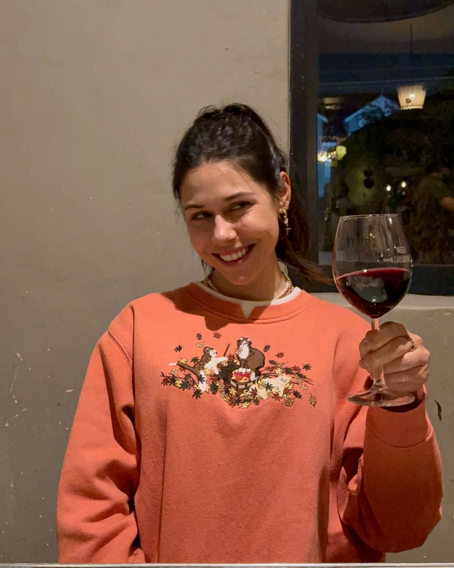 Paige smiling with a glass of red wine at The Woodlands Eatery wine and food pairing event