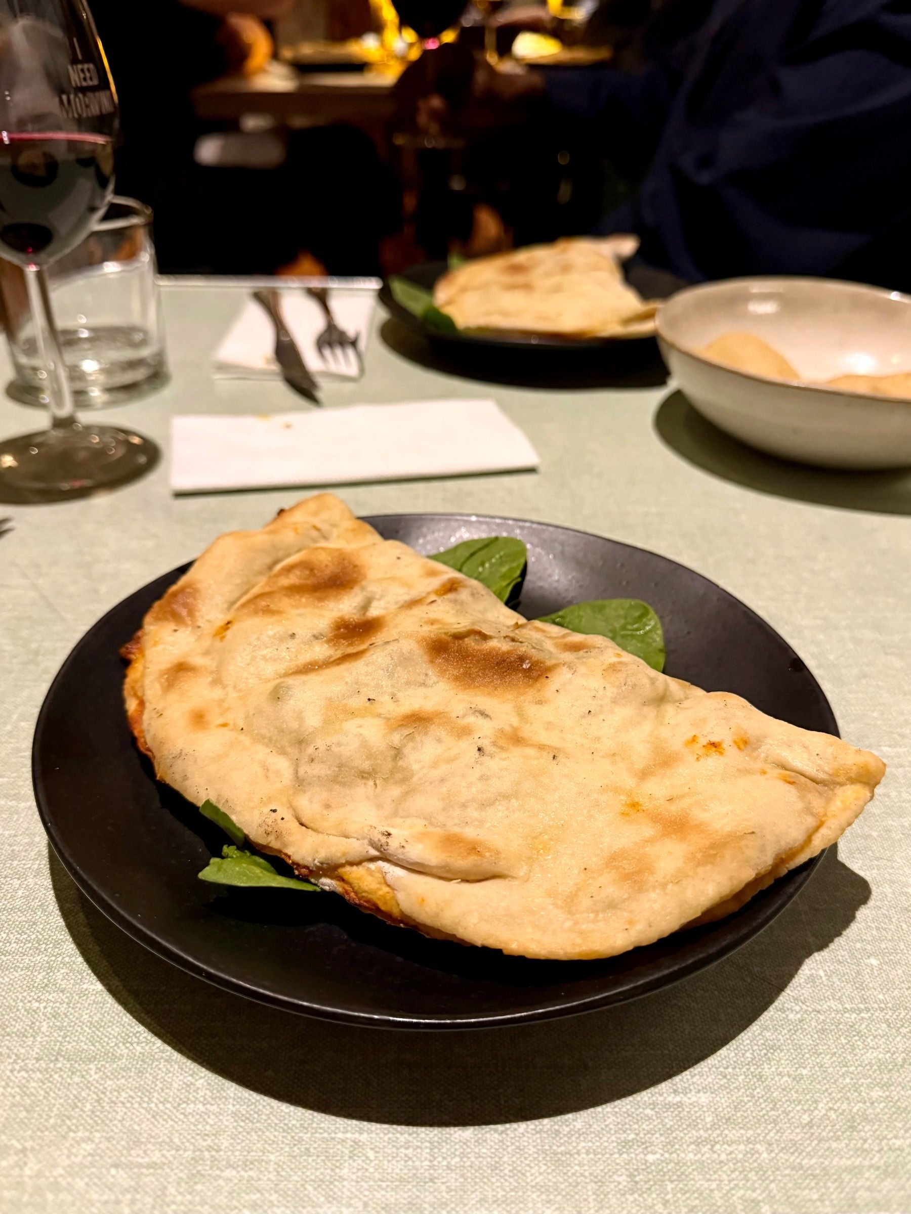 Golden baked calzone served at The Woodlands Eatery paired with Zevenwacht wine.
