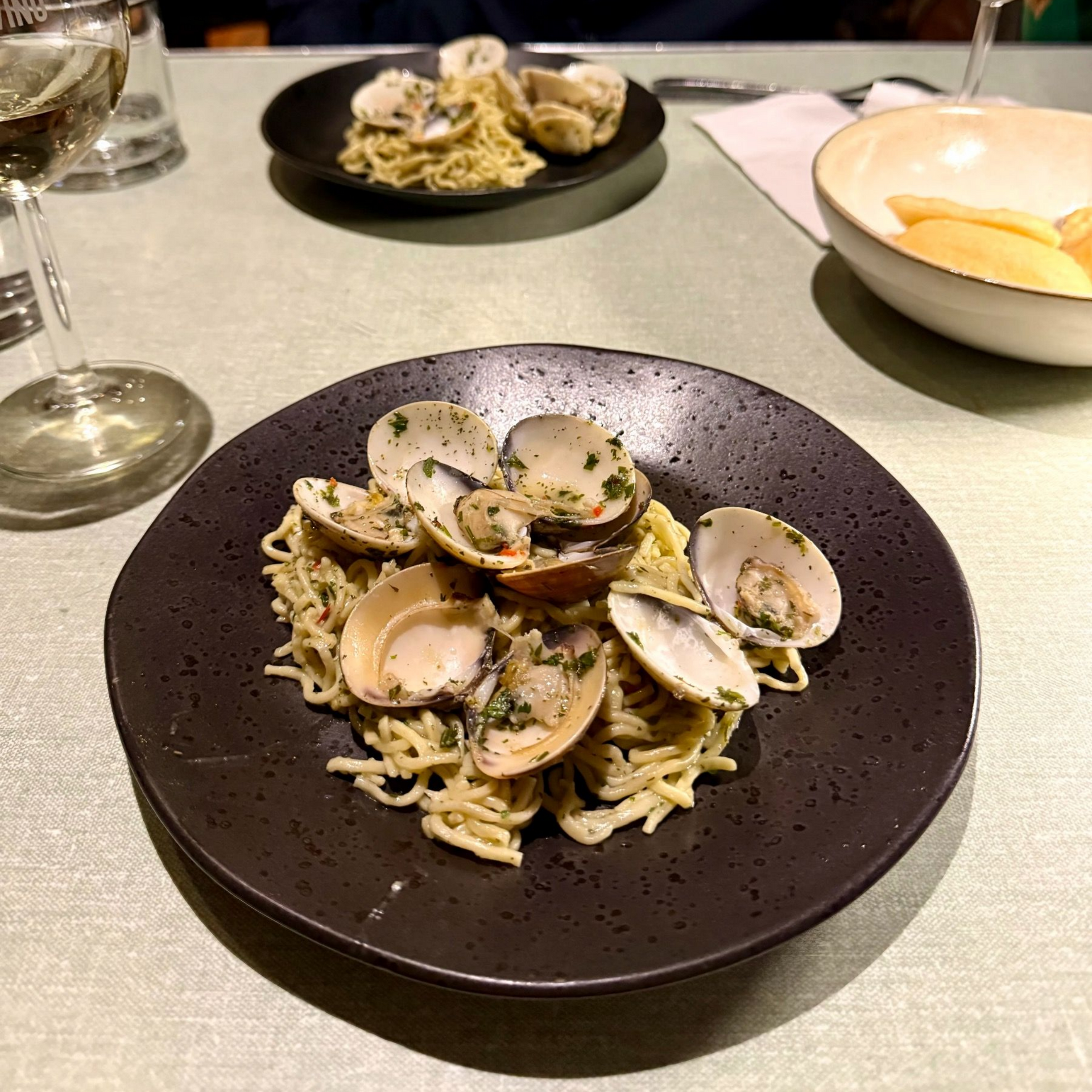 Clam pasta in a dark bowl at The Woodlands Eatery during a Zevenwacht wine pairing dinner