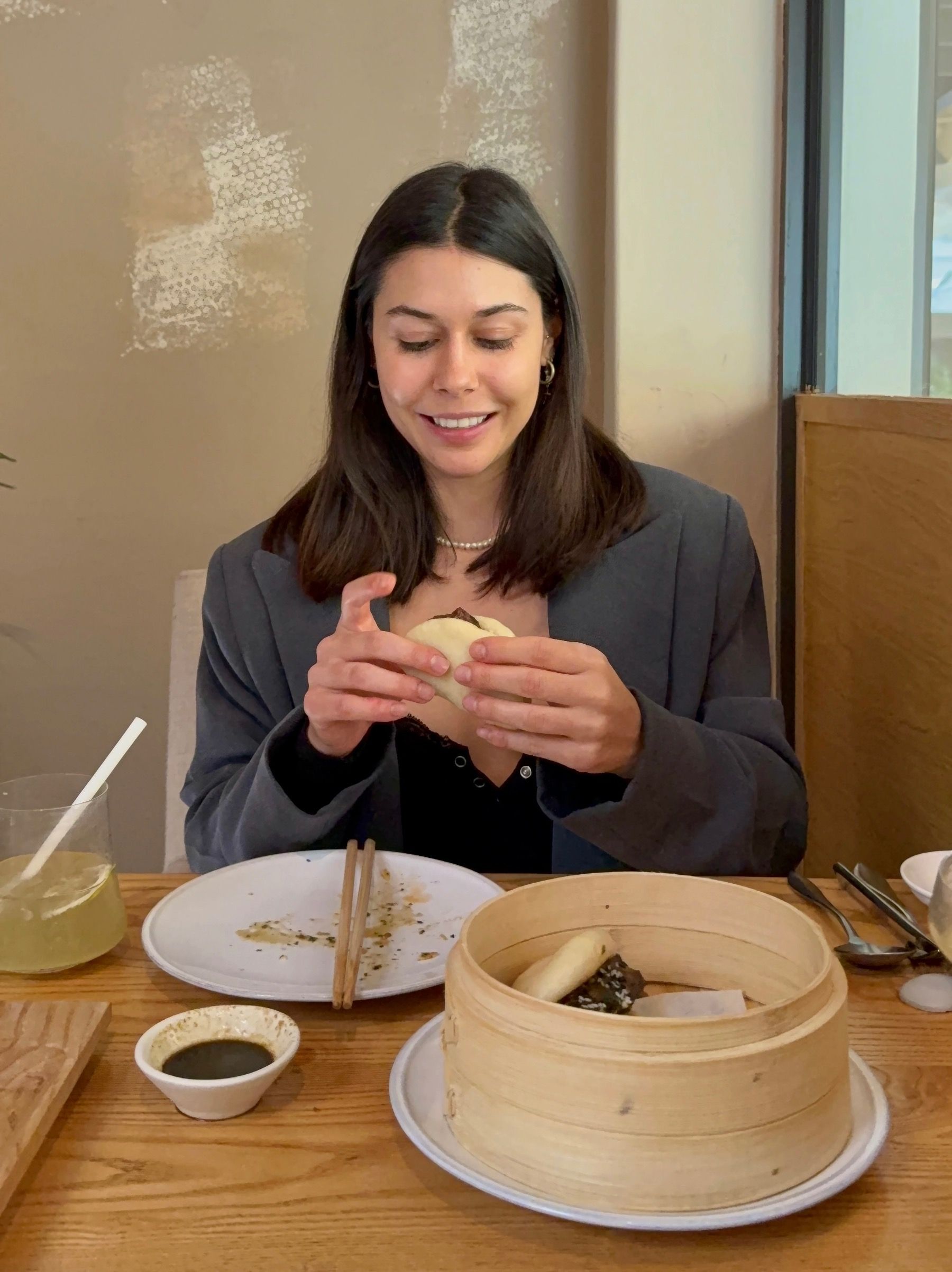 Paige holding fluffy steamed bao buns at Yama Asian Eatery in Cape Town