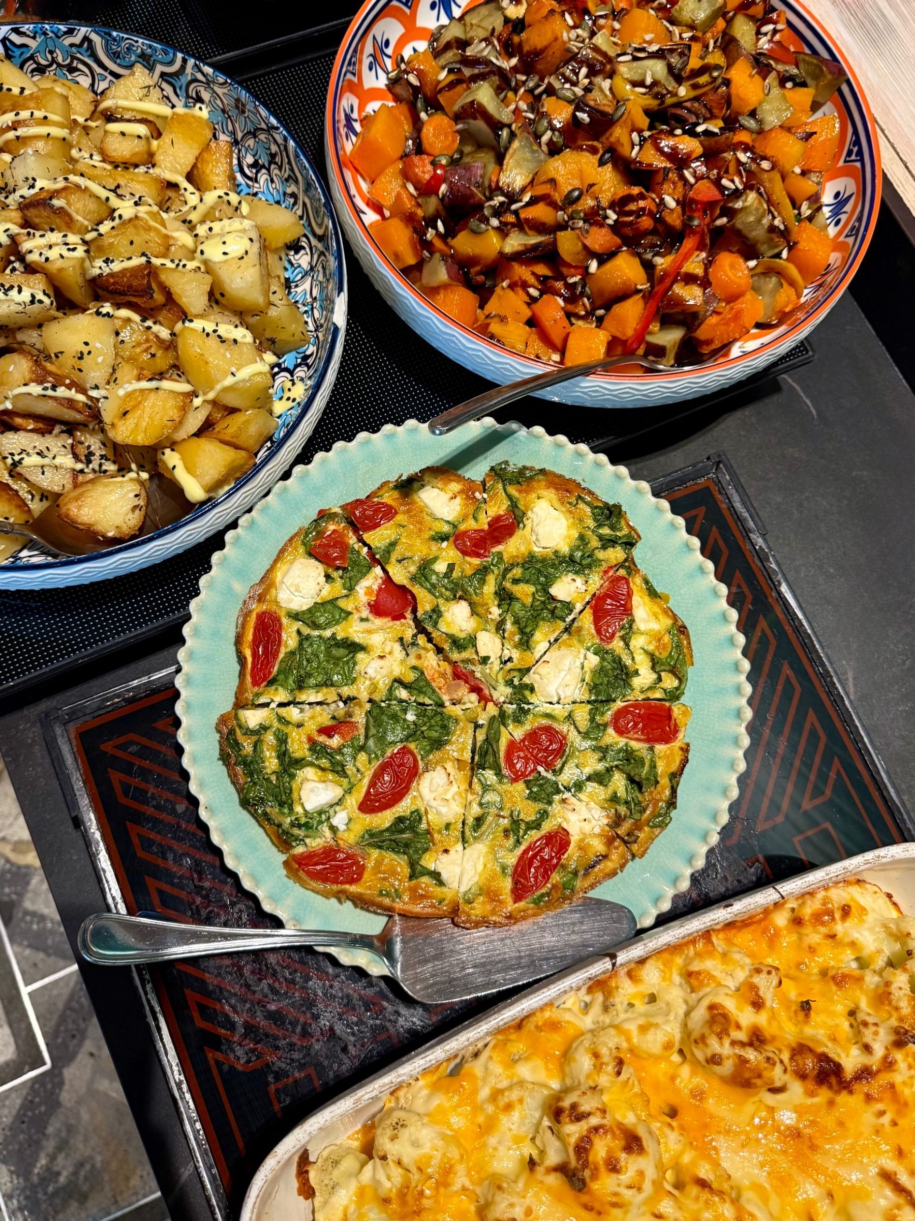 Yumcious Cafe warm harvest table spread. Rice, cauliflower bake, frittata, roasted vegetables, roasted potatoes