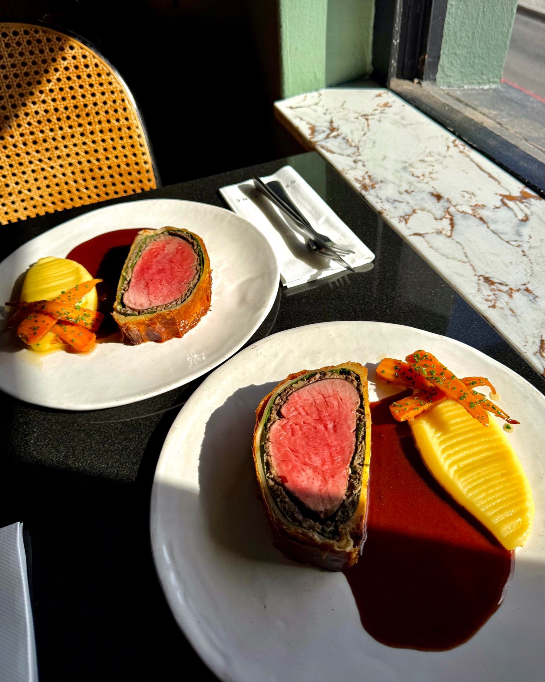 Beef Wellington served with seasonal accompaniments at Grub & Vine.