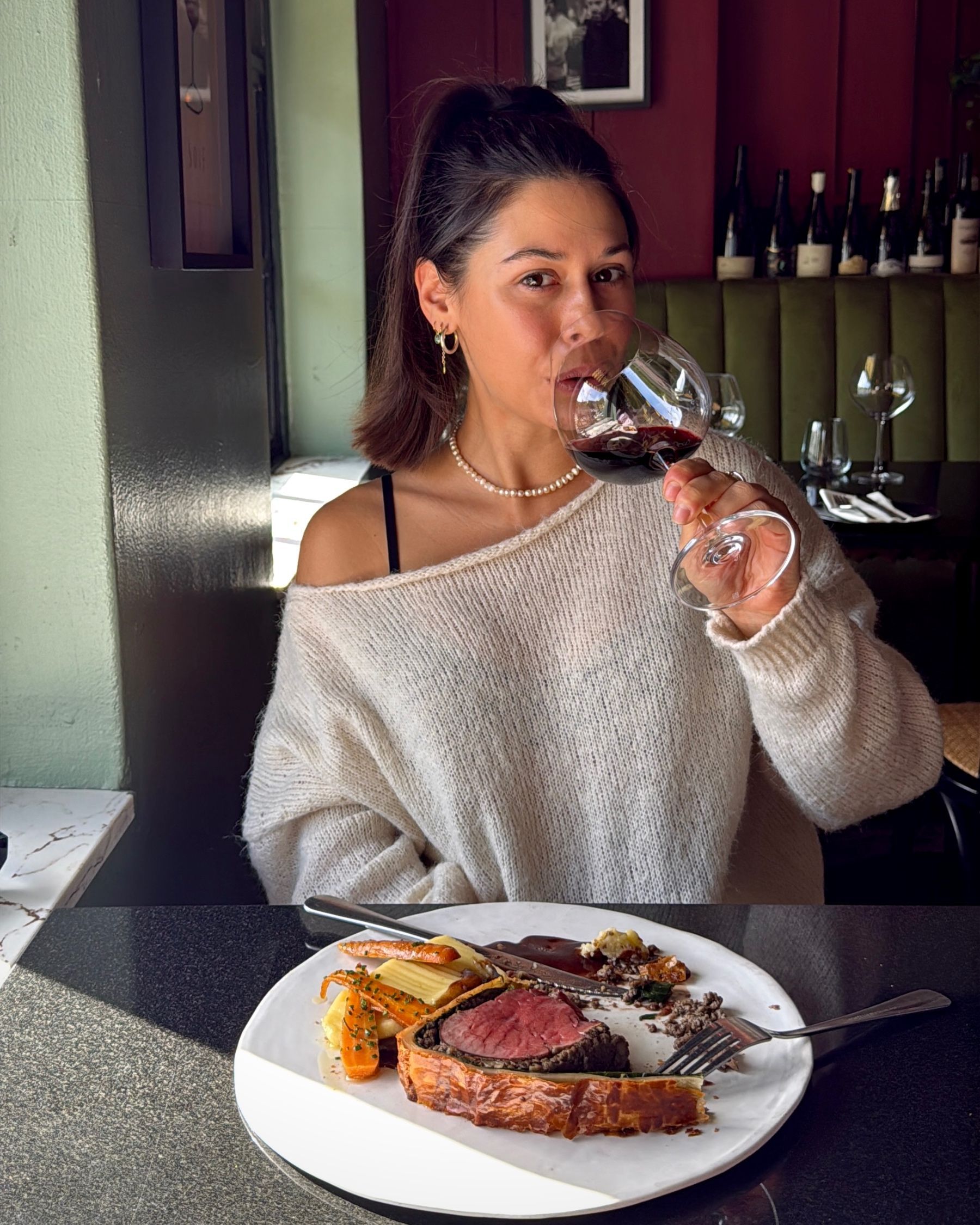 Paige enjoying red wine with the Beef Wellington.