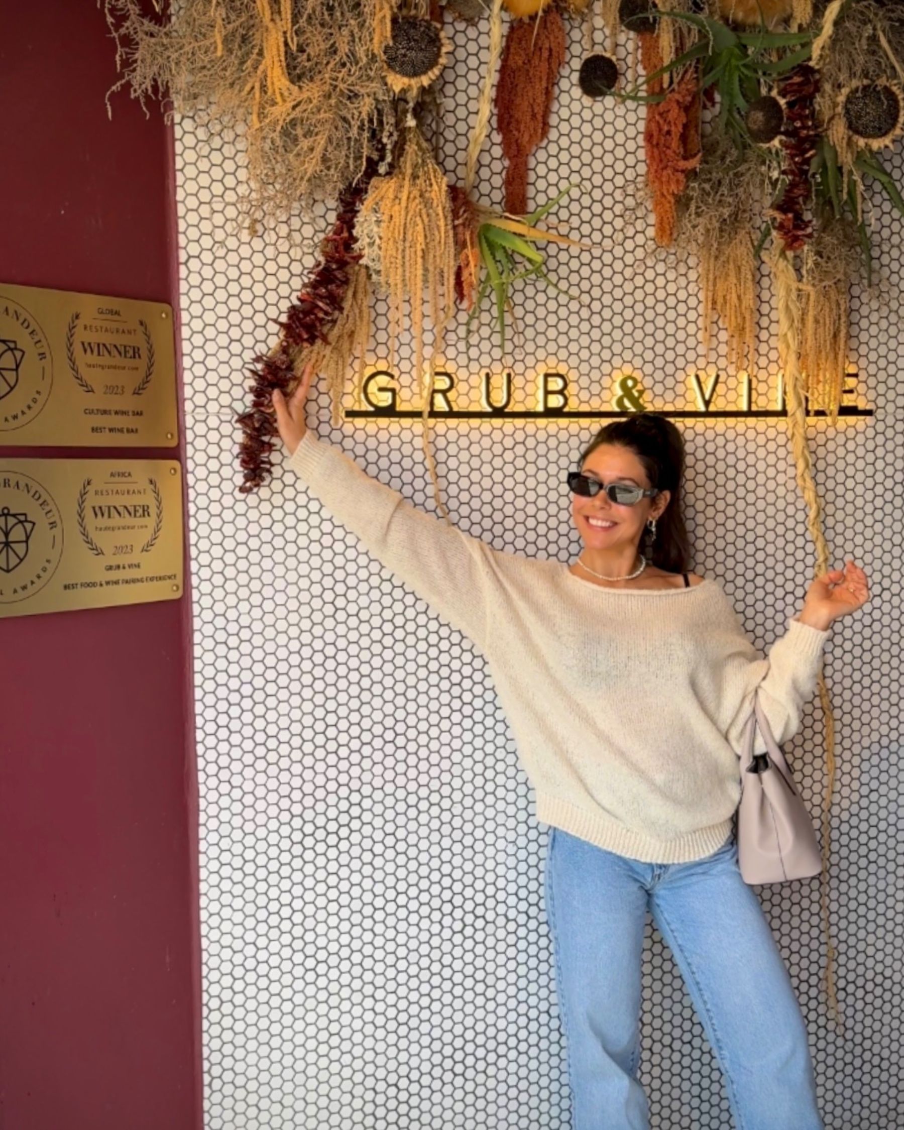 Paige standing beside the Grub & Vine restaurant sign.