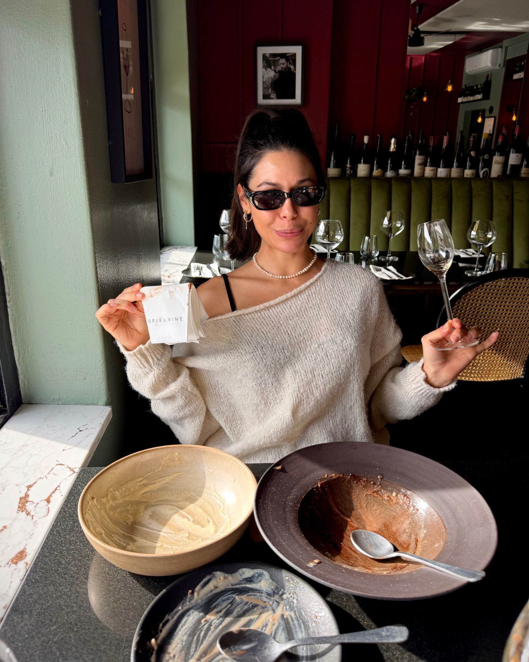 Paige smiling beside the empty dessert plates after dinner.