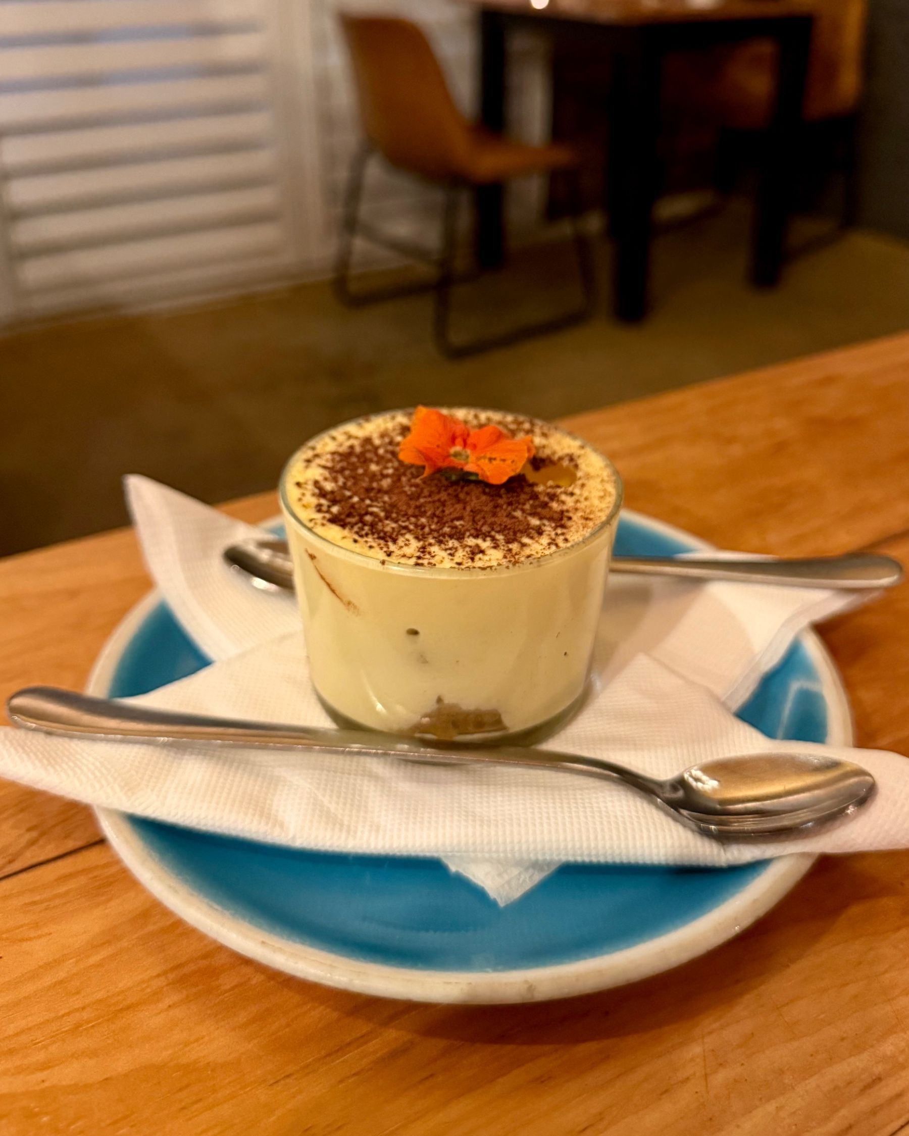 Classic tiramisu served in a glass dessert dish.
