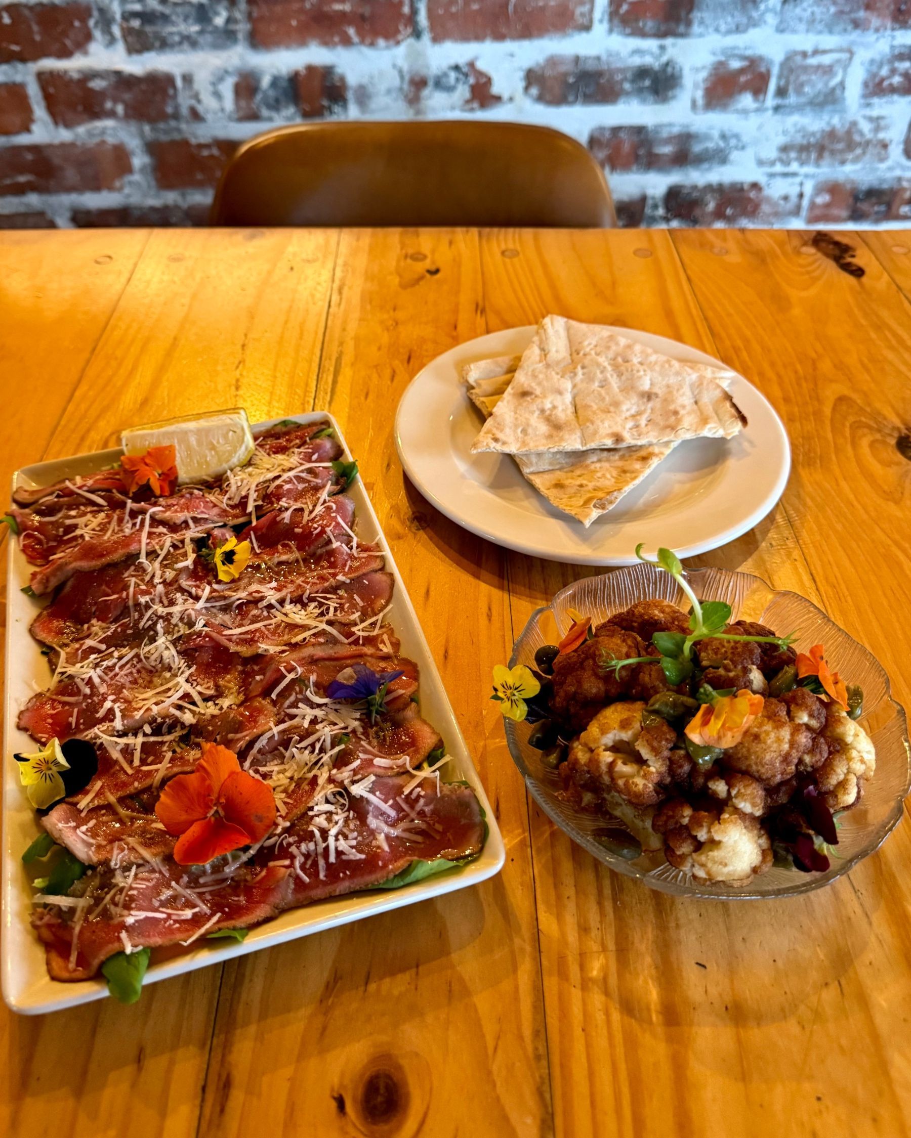 Beef carpaccio, flatbread and a vegan cauliflower dish served for starters.
