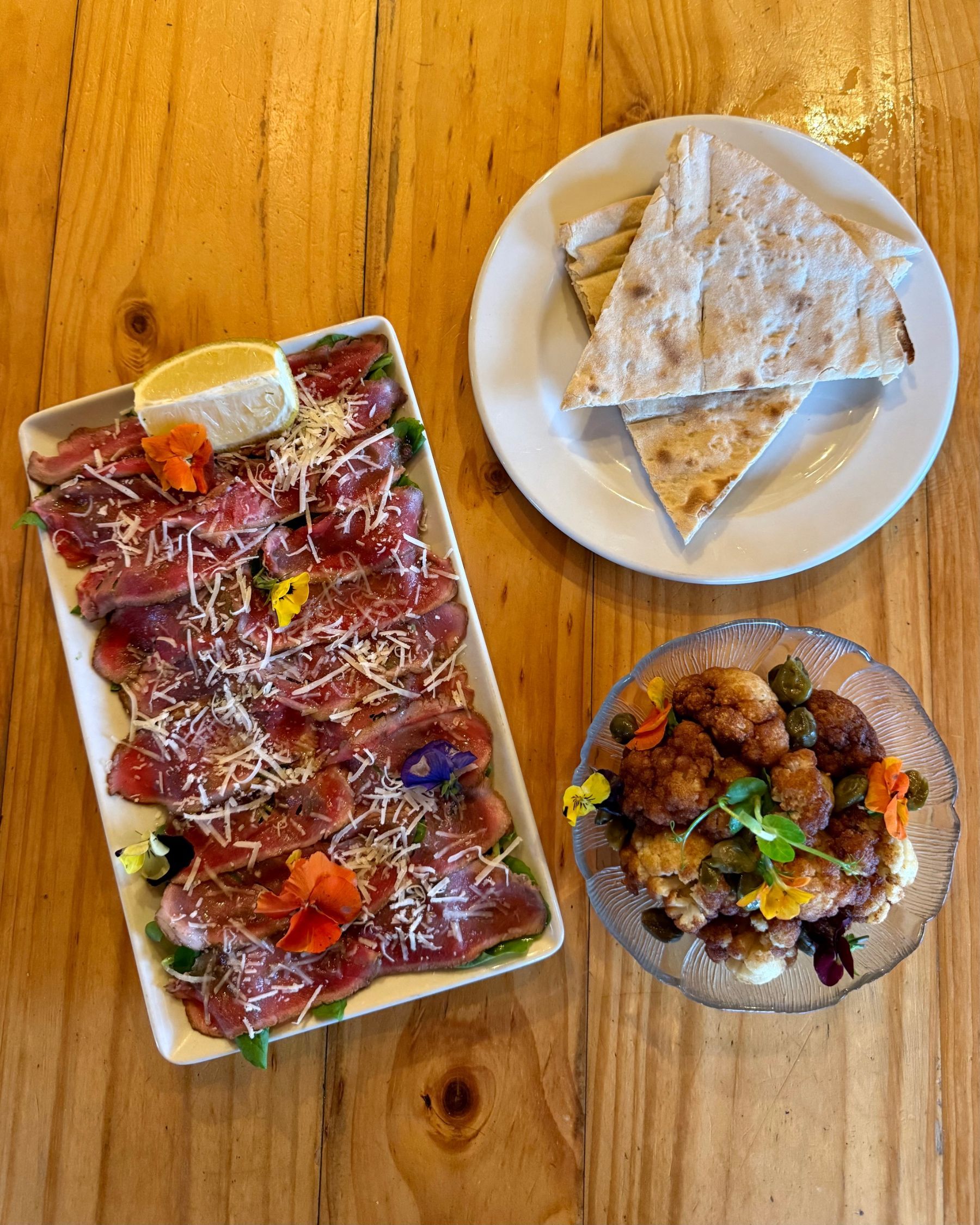Beef carpaccio, flatbread and a vegan cauliflower dish served for starters.
