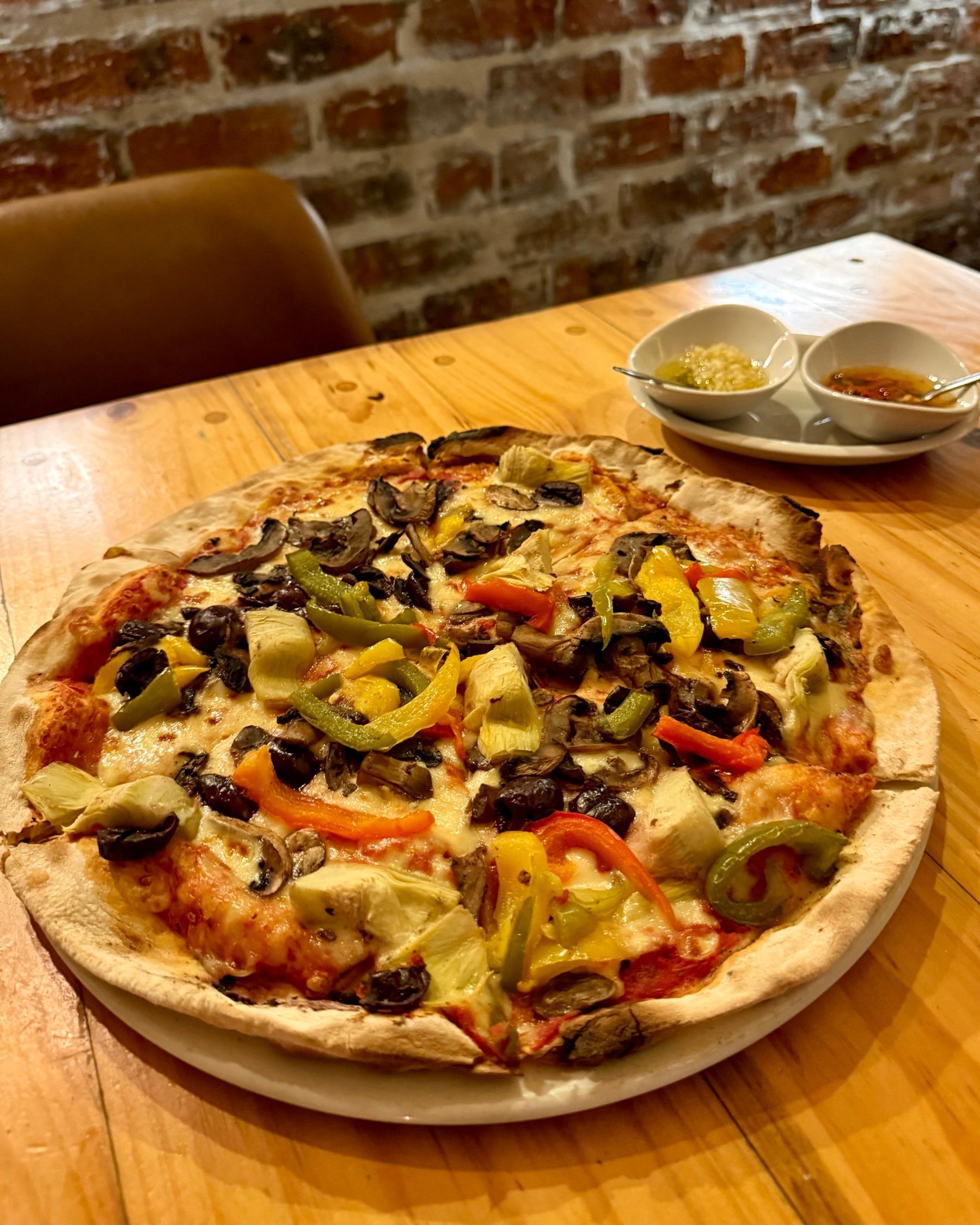 Close-up of Massimo’s vegetarian pizza topped with colourful roasted vegetables.
