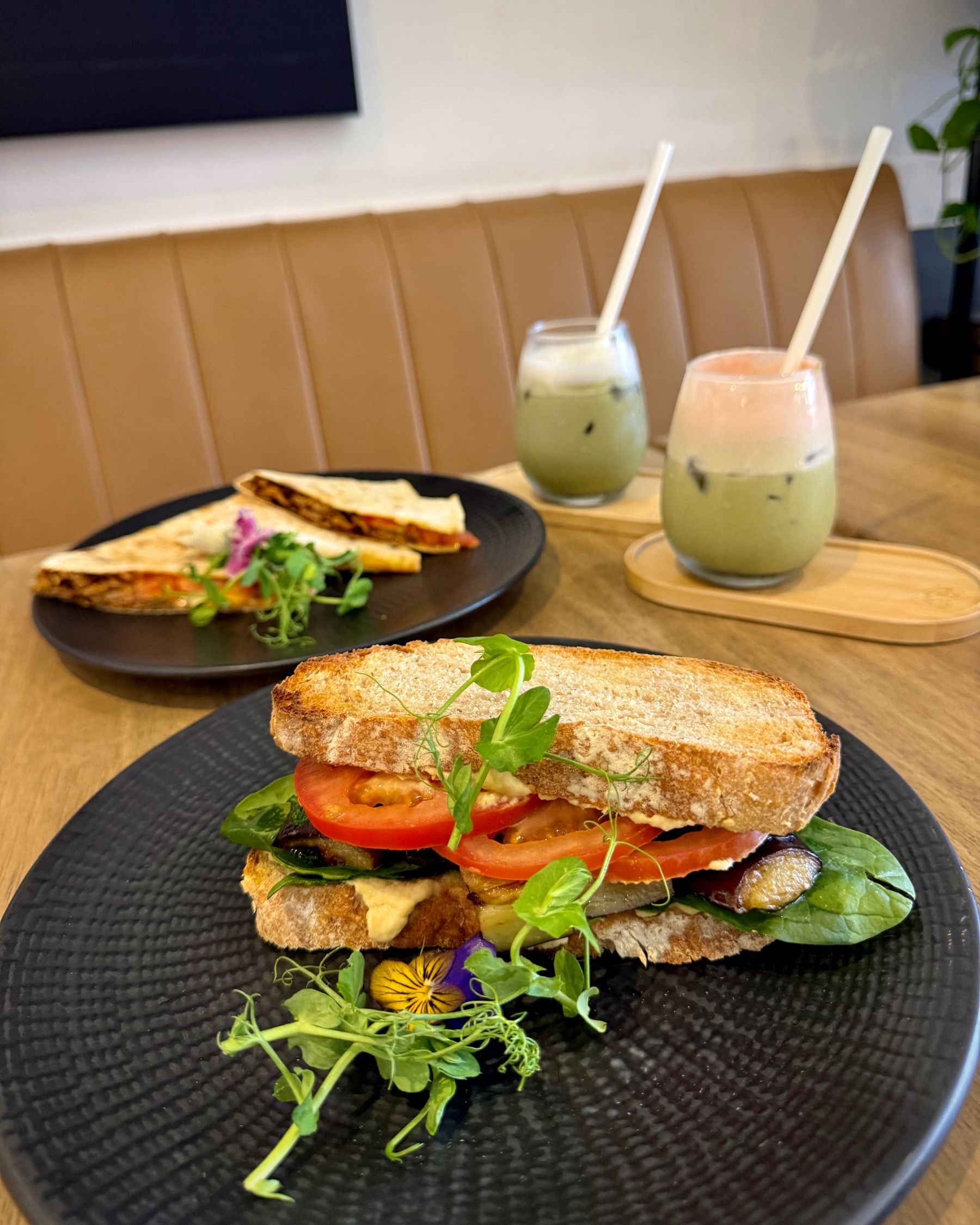 Mediterranean Sourdough Sandwich in the foreground with the Pulled Beef Flatbread and matcha behind