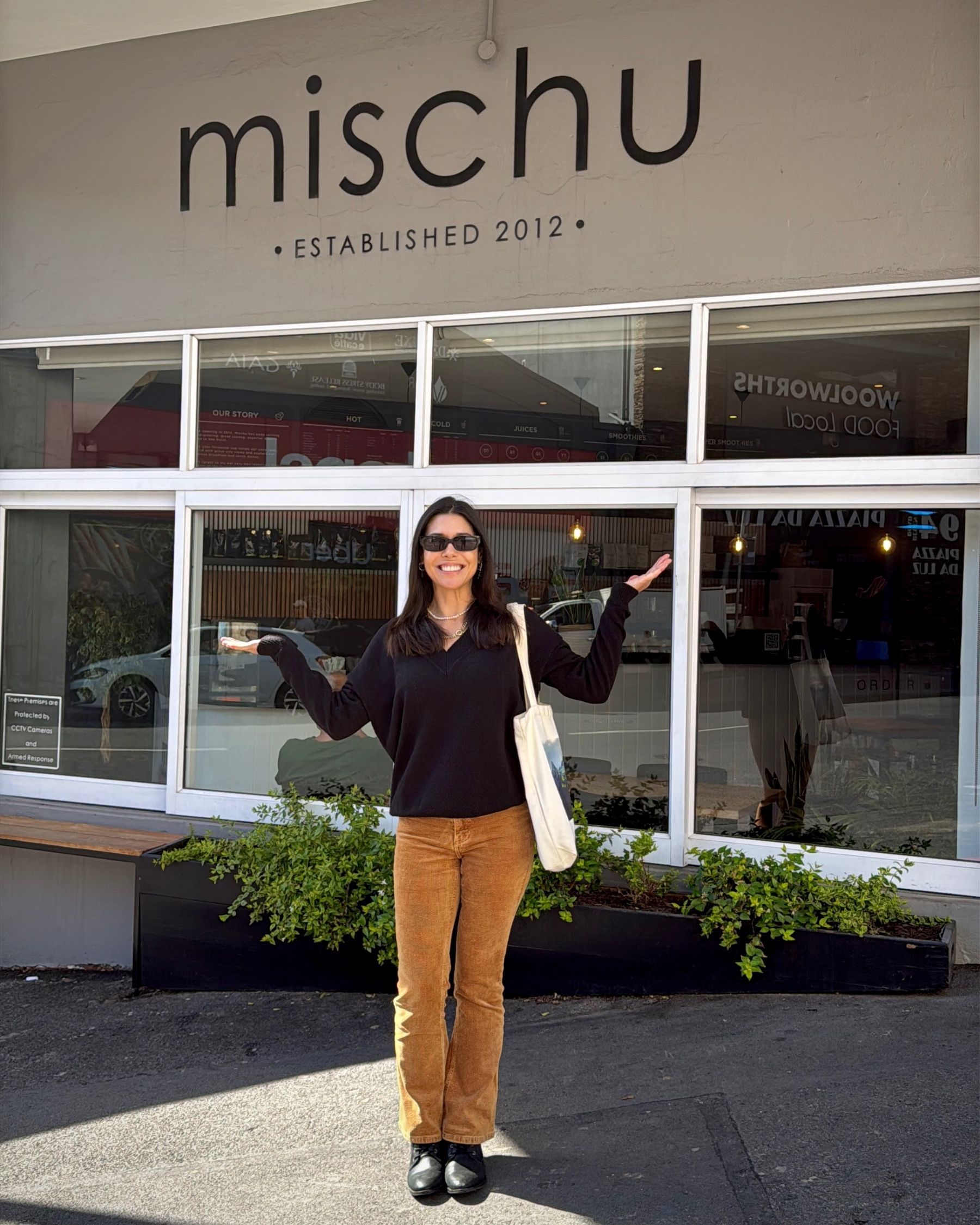 Paige standing outside the Mischu sign in Sea Point, Cape Town.